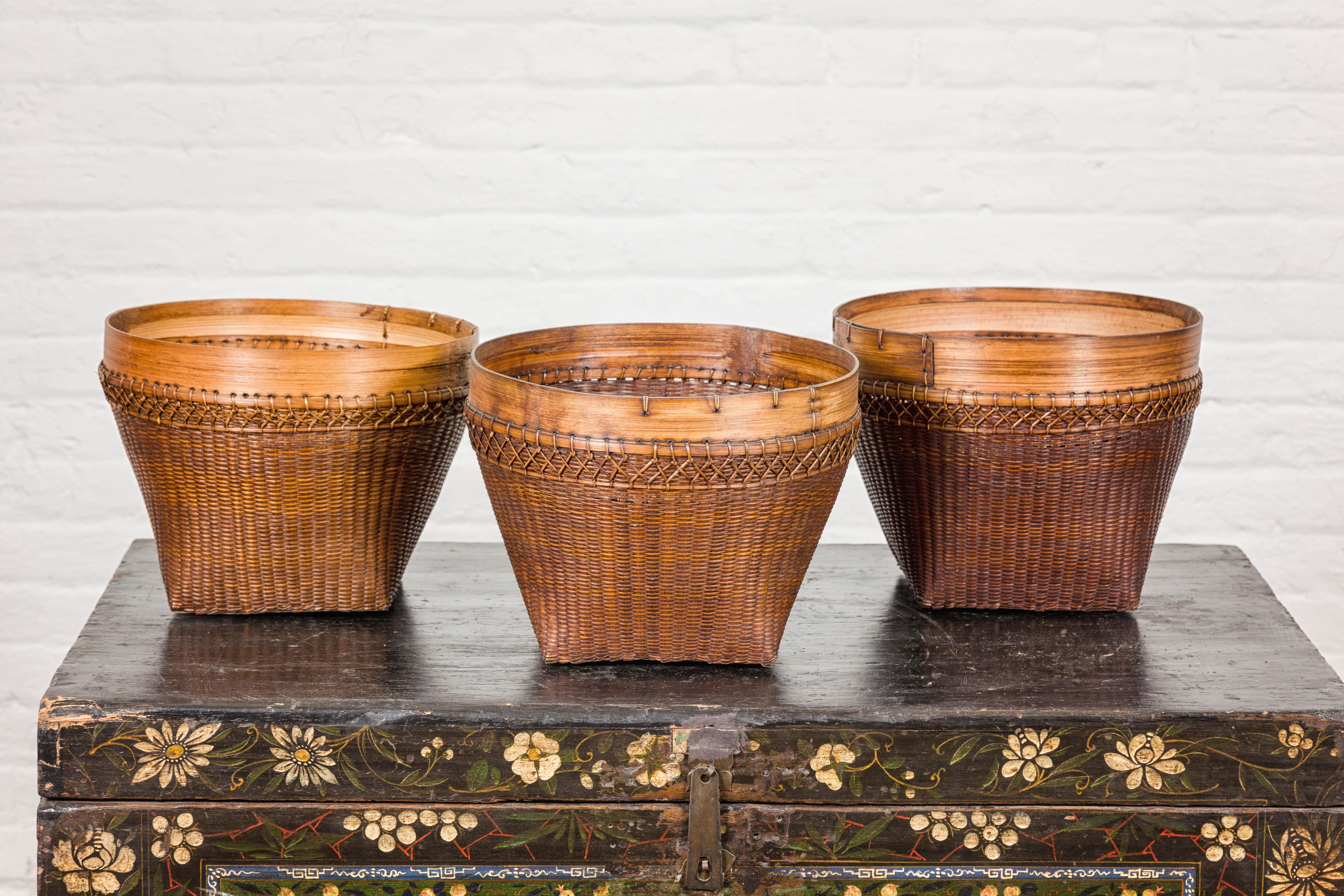 Un cesto in rattan vintage intrecciato a mano in stile country con bordo in bambù e linee affusolate. Questo cesto vintage in rattan intrecciato a mano, caratterizzato da un bordo in bambù e da graziose linee affusolate, emana un fascino rustico e