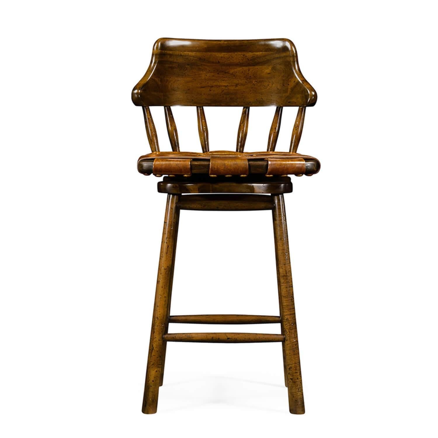 Country style walnut bar stool with a curbed solid backrest supported by turned spindles, above a webbed antiqued leather revolving sear and raised on tapered legs with a stretcher base.

Dimensions: 19.5