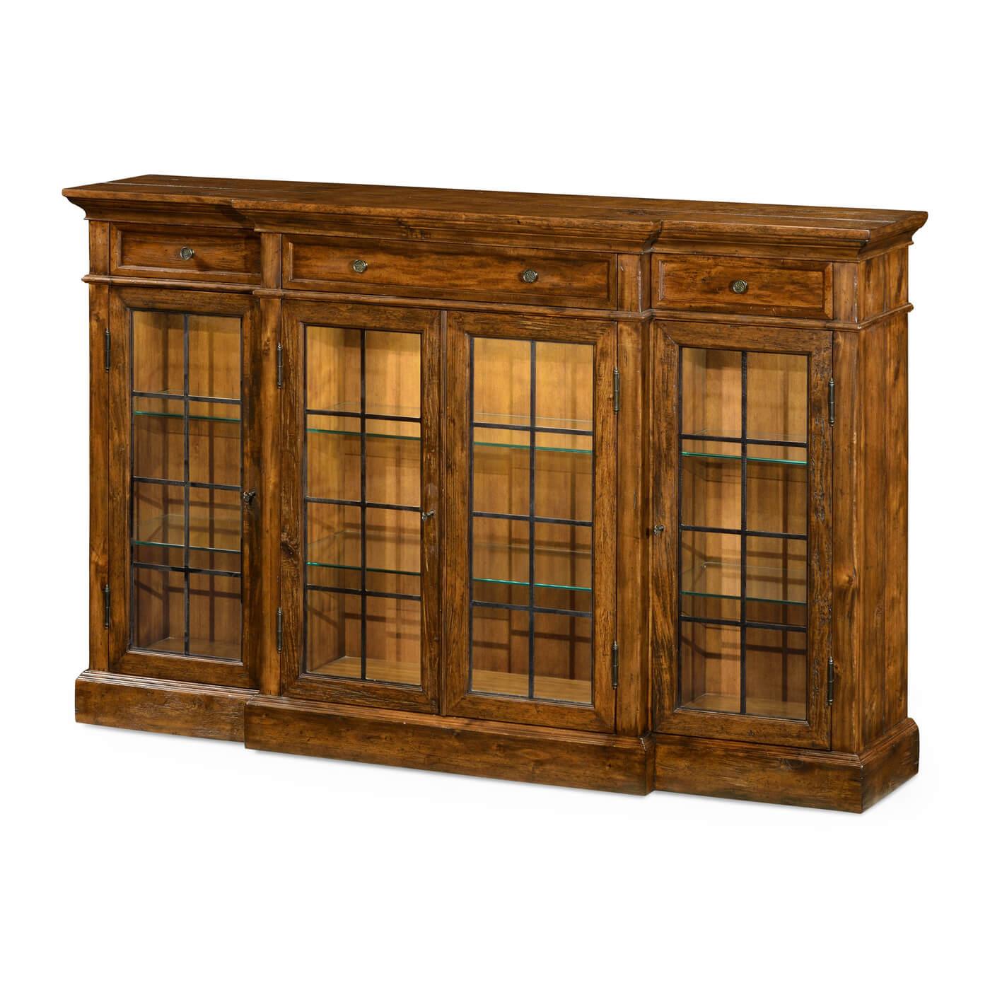 Country walnut four door breakfront display cabinet with interior lighting. The glazed doors flanked. Three shallow drawers at the top with brass handles.

Dimensions: 77 