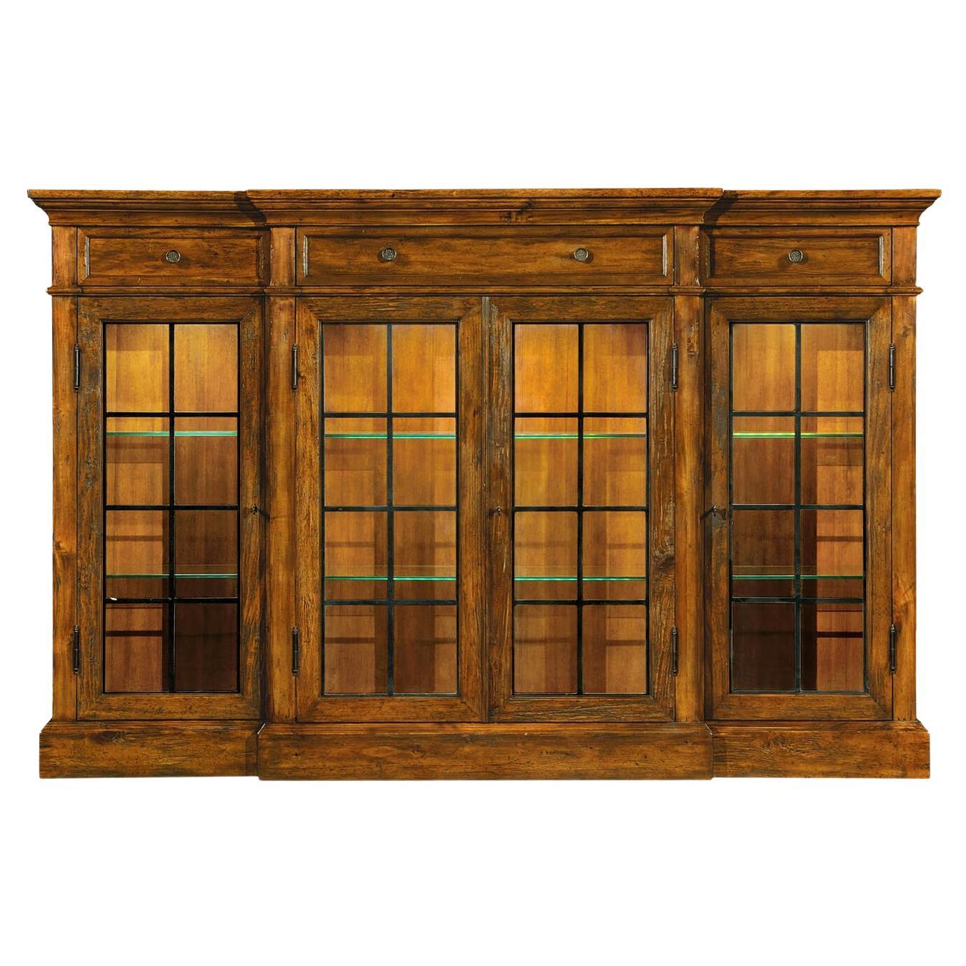Vitrina rústica de cuatro puertas en nogal con iluminación interior. Las puertas acristaladas flanqueaban. Tres cajones poco profundos en la parte superior con tiradores de latón.

Dimensiones: 77
