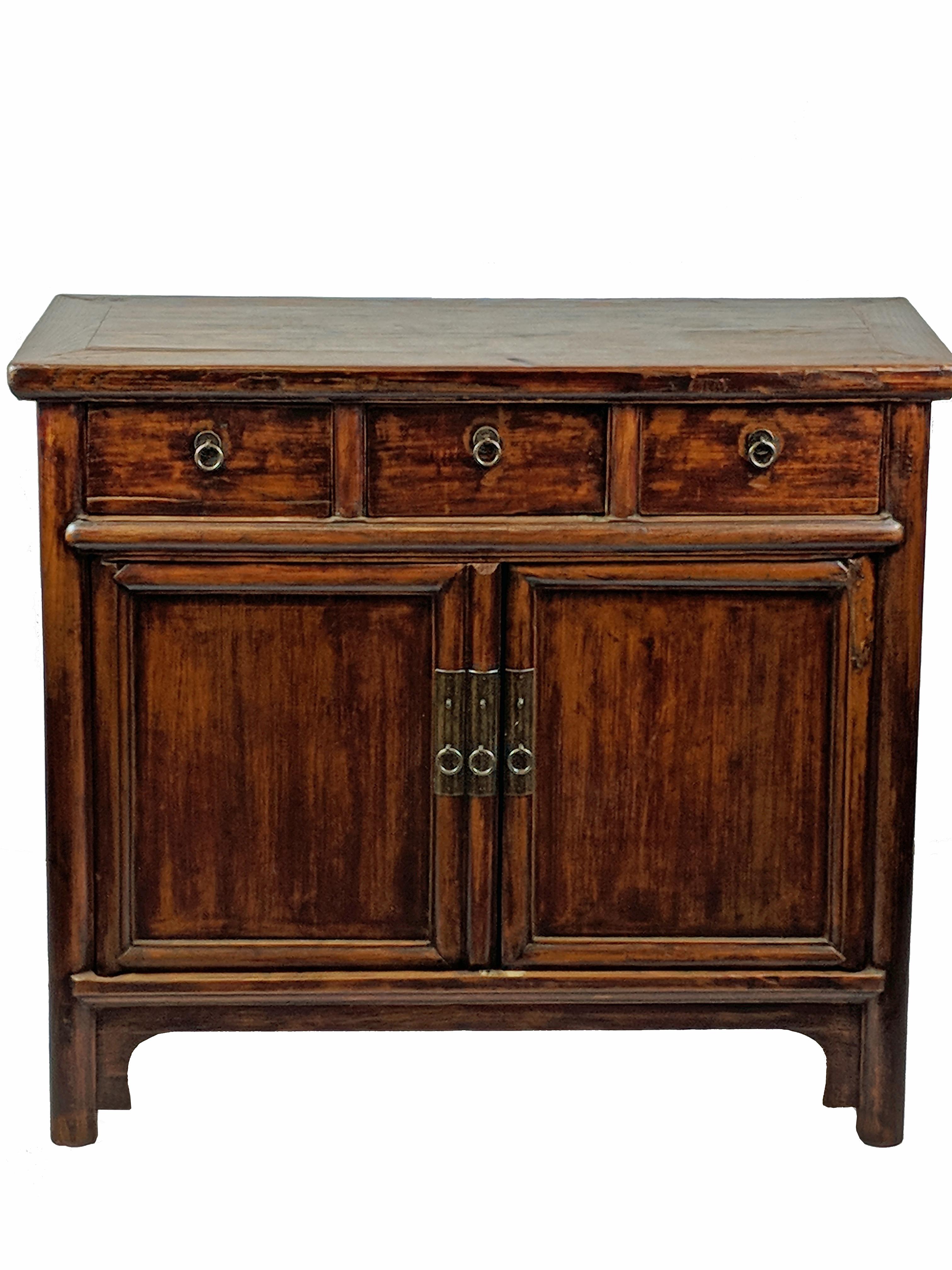A simple countryside cabinet with its original paint and natural textured wood. It has round smooth posts around doors, drawers, and frame. Three drawers and two doors open to a main compartment. This quietly elegant antique cabinet will make a
