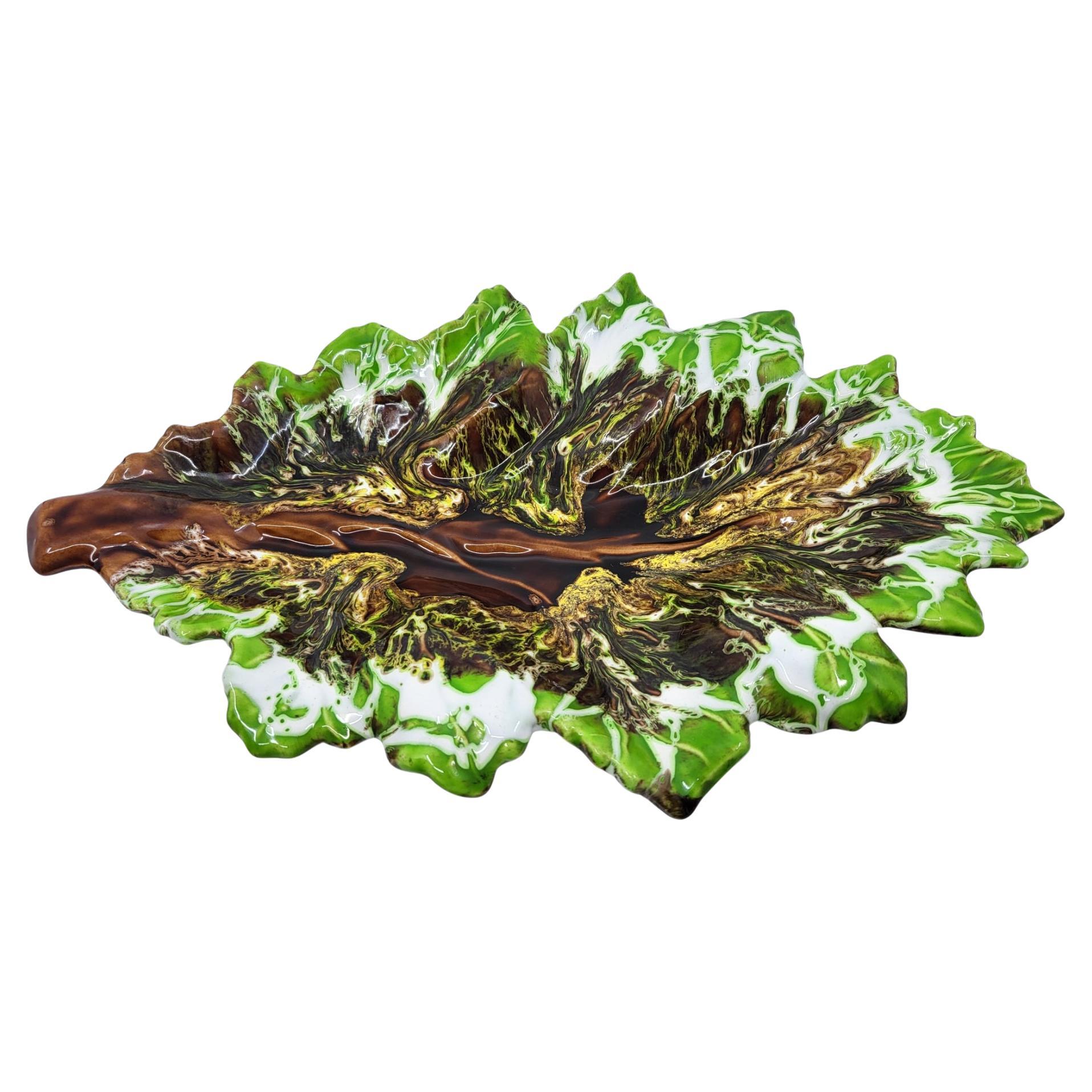 Cette magnifique coupe en forme de feuille est à la fois une pièce décorative et un élégant support pour des fruits. Elle se distingue par ses couleurs d'origine, qui ont su conserver toute leur vivacité au fil du temps. Il est en effet peu commun