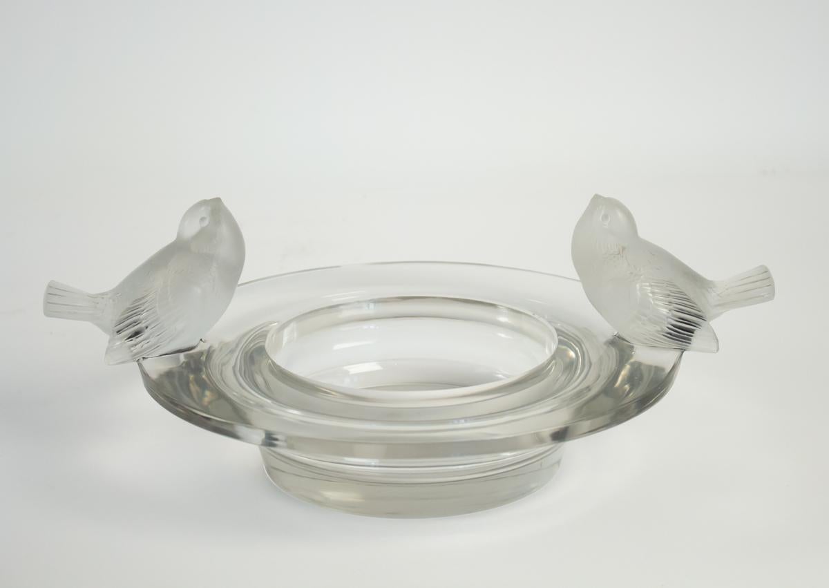 René Lalique bowl Deux Moineaux Moqueurs.
 41 centimeters total diameter round clear opposing frosted bird figures across from each other on top of the flat rim Lalique Bowl Signed R.Lalique .france
Biblliography : marcilhac 
Model: 412 Circa