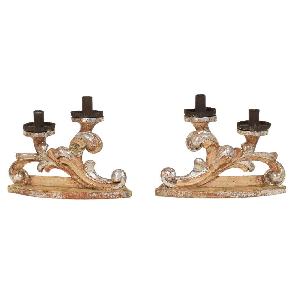 Pareja de candelabros barrocos italianos del siglo XVIII de madera tallada y plateada en venta
