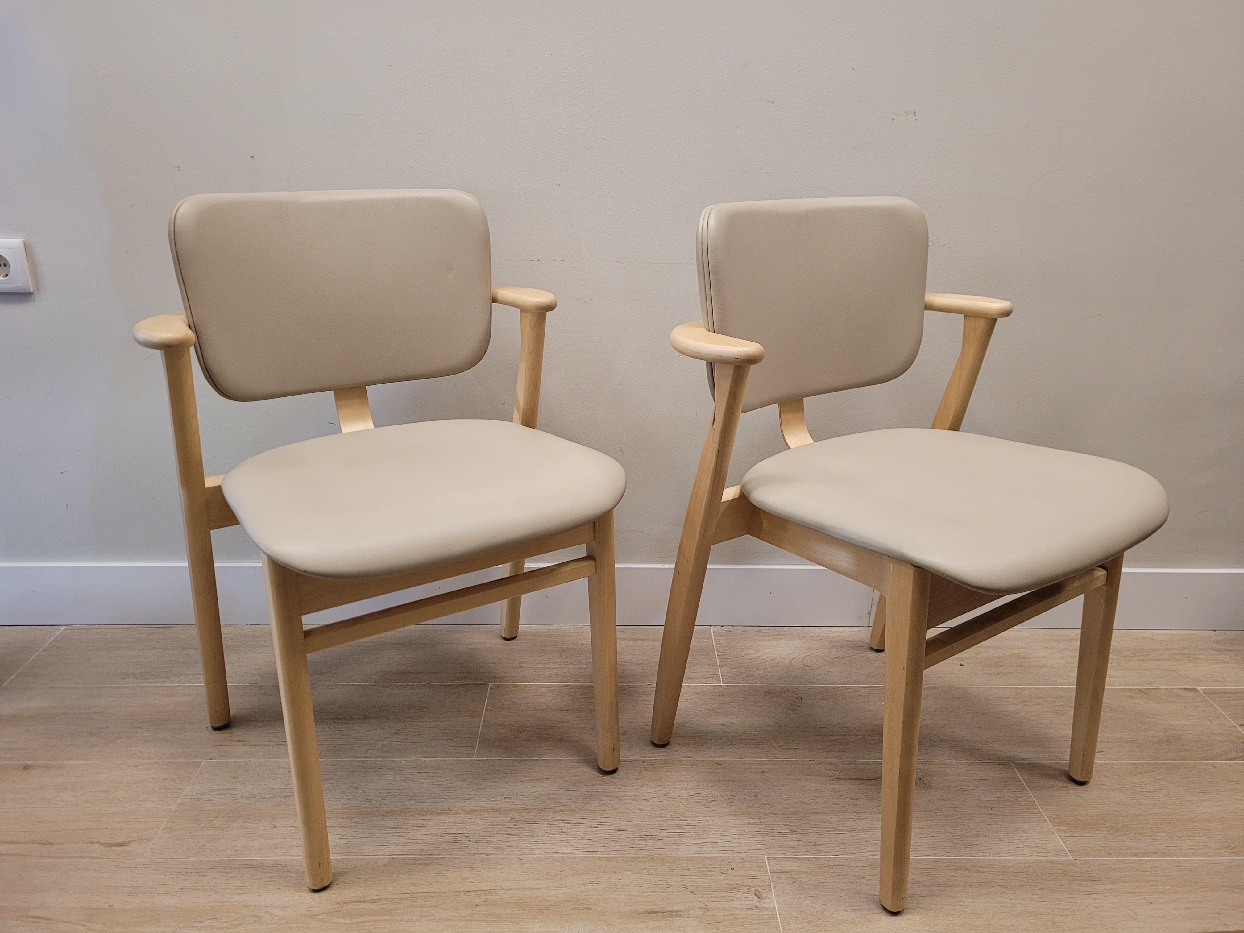 Beautiful Pair of DOMUS model chairs, designed by Ilmari Tapiovaara, with birch structure, seat and back in beige leather. It was created in 1946 as part of the furniture for the Domus Academica student housing complex in Helsinki, soon becoming a