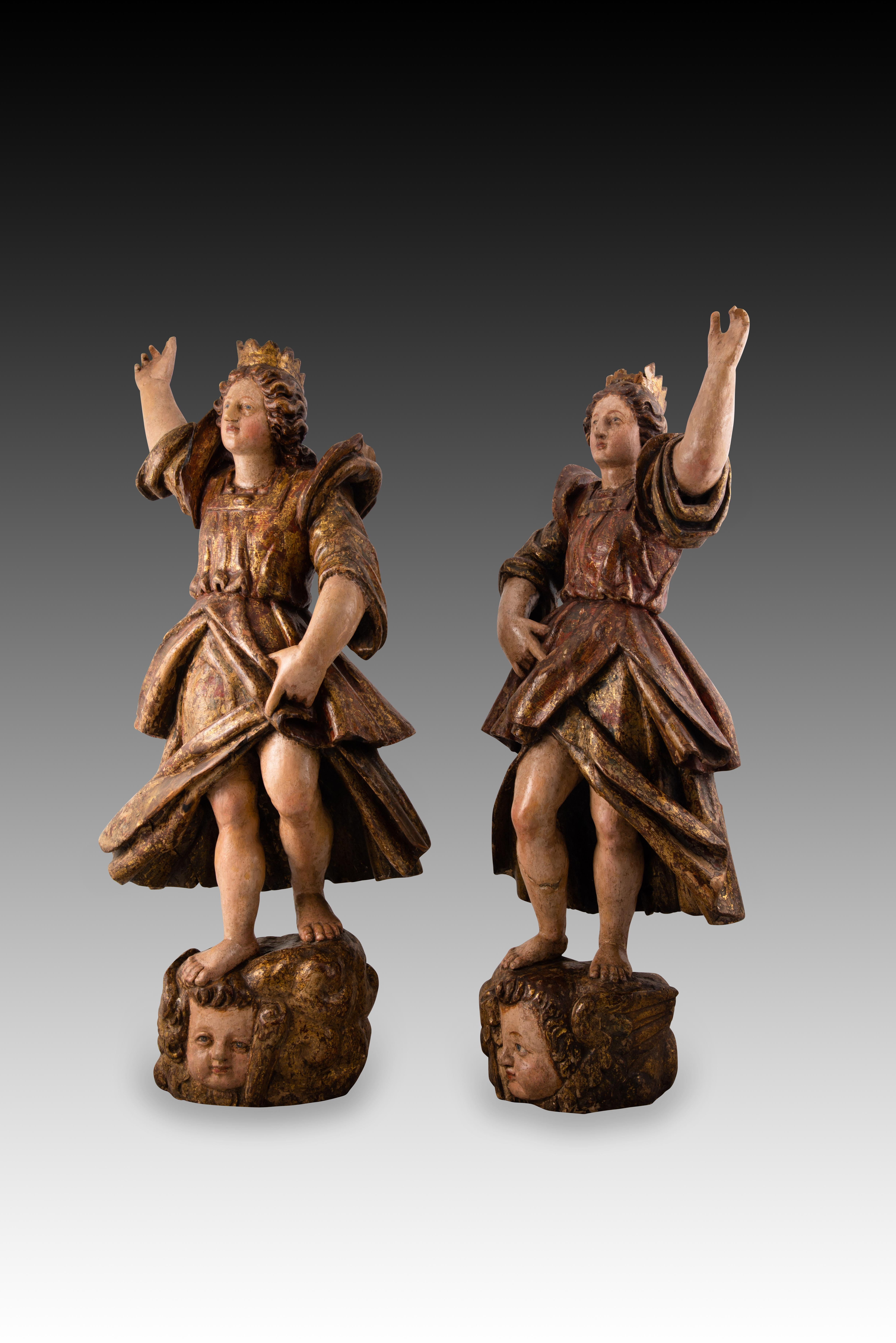 Couple d'anges torcheurs. Bois sculpté et polychrome. École espagnole, 17e siècle.
 Ils ont des défauts. 
Paire de sculptures en bois polychrome de forme humaine représentant deux anges levant chacun un bras et situés sur des nuages aux têtes