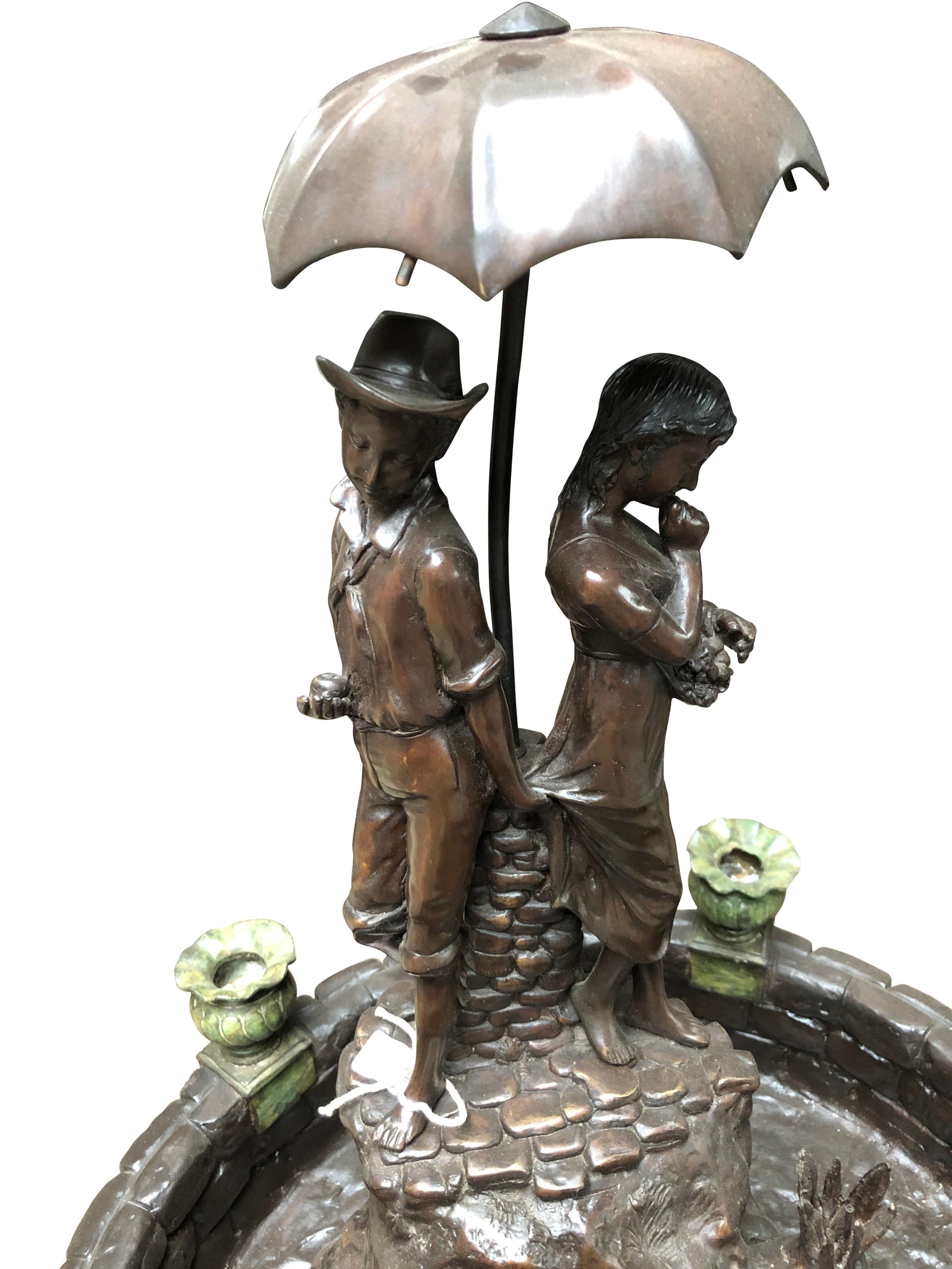 A gorgeous couple with umbrella, bronze fountain, 20th century. This large fountain is perfect for the garden, with a superb patina finish. Of course this being bronze means it will not rust. Offered in excellent condition.