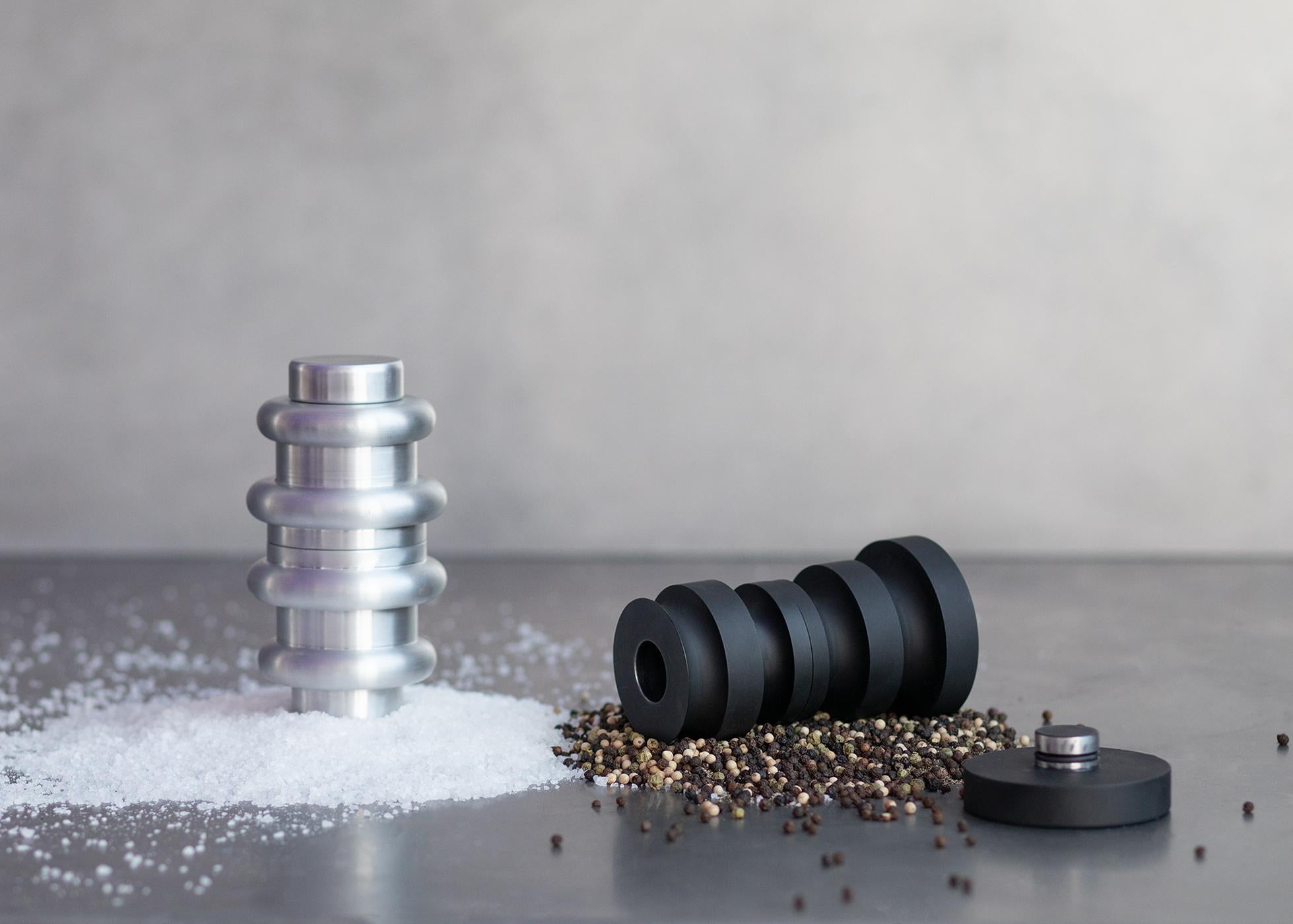 Inspired by mid-century Danish design, the Coupled Salt and Pepper Mills resemble wood turned objects and reimagine them in new and classic materials. Since salt and pepper go hand in hand, the forms nest into one another, echoing their function.