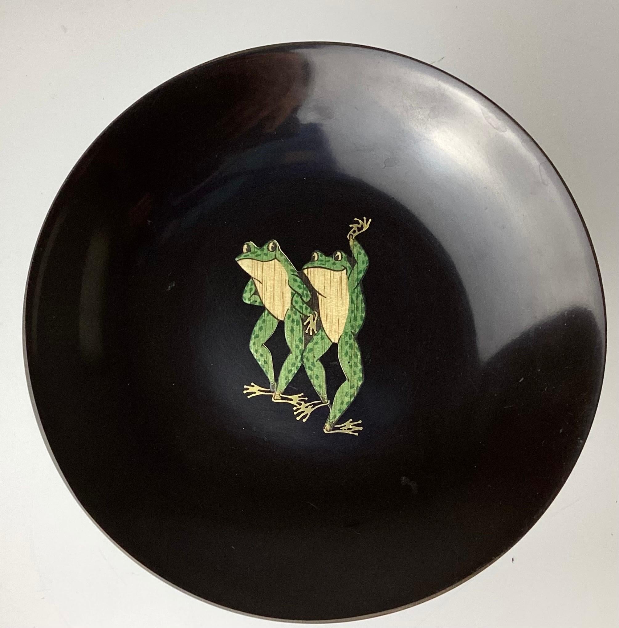 Couroc bowl with frogs. Resin, Monterey, California 1970s. Charming whimsical oval tray decorated with dancing frogs. Dimensions: 9 5/8 inches deep x 12 1/2 inches wide x 3/4 inches high Guthrie Courvoisier and his wife, Moira Wallace, established