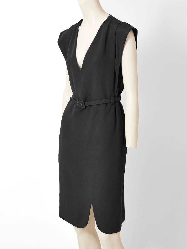 André Corrèges, black, silk, heavy crepe, belted dress having a deep V neckline and pleated accents from the shoulder to the waist. There is an off centered curved slit detail at the hem.