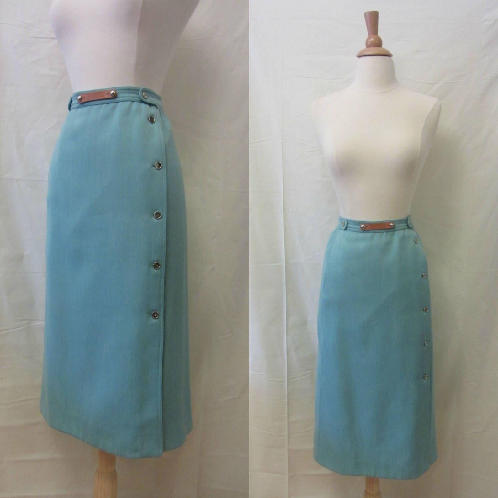 Falda lápiz Courrèges vintage. azul huevo de petirrojo. cintura alta. silueta recta. logotipo de piel marrón desmontable en la cintura de la falda. herrajes metálicos plateados en la cintura de la falda. un solo bolsillo en la cadera. estilo