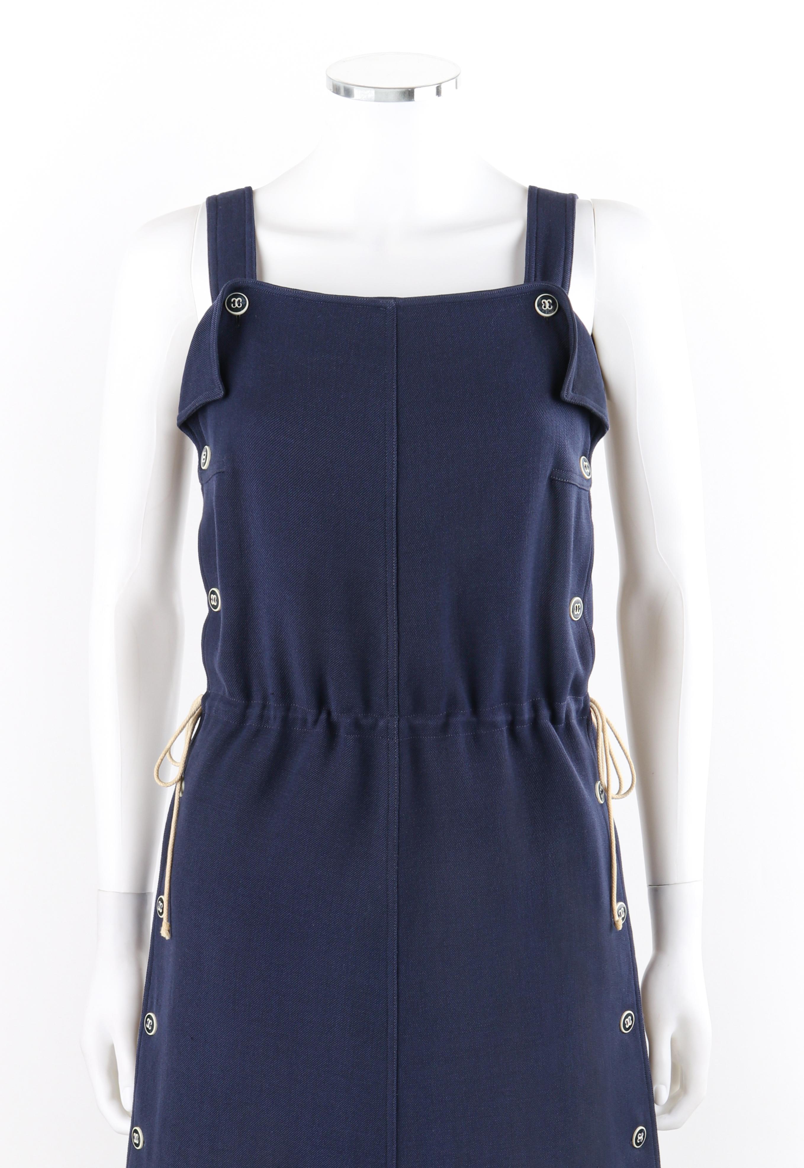 COURREGES c.1970’s Navy Blue Button Up Tie Cinch Waist Sleeveless Jumper Dress
 
Circa: 1970’s
Label(s): Courreges Paris
Designer: Andre Courreges
Style: A-line jumper dress
Color(s): Dark blue and white
Lined: Yes
Marked Fabric Content: “95% Wool,