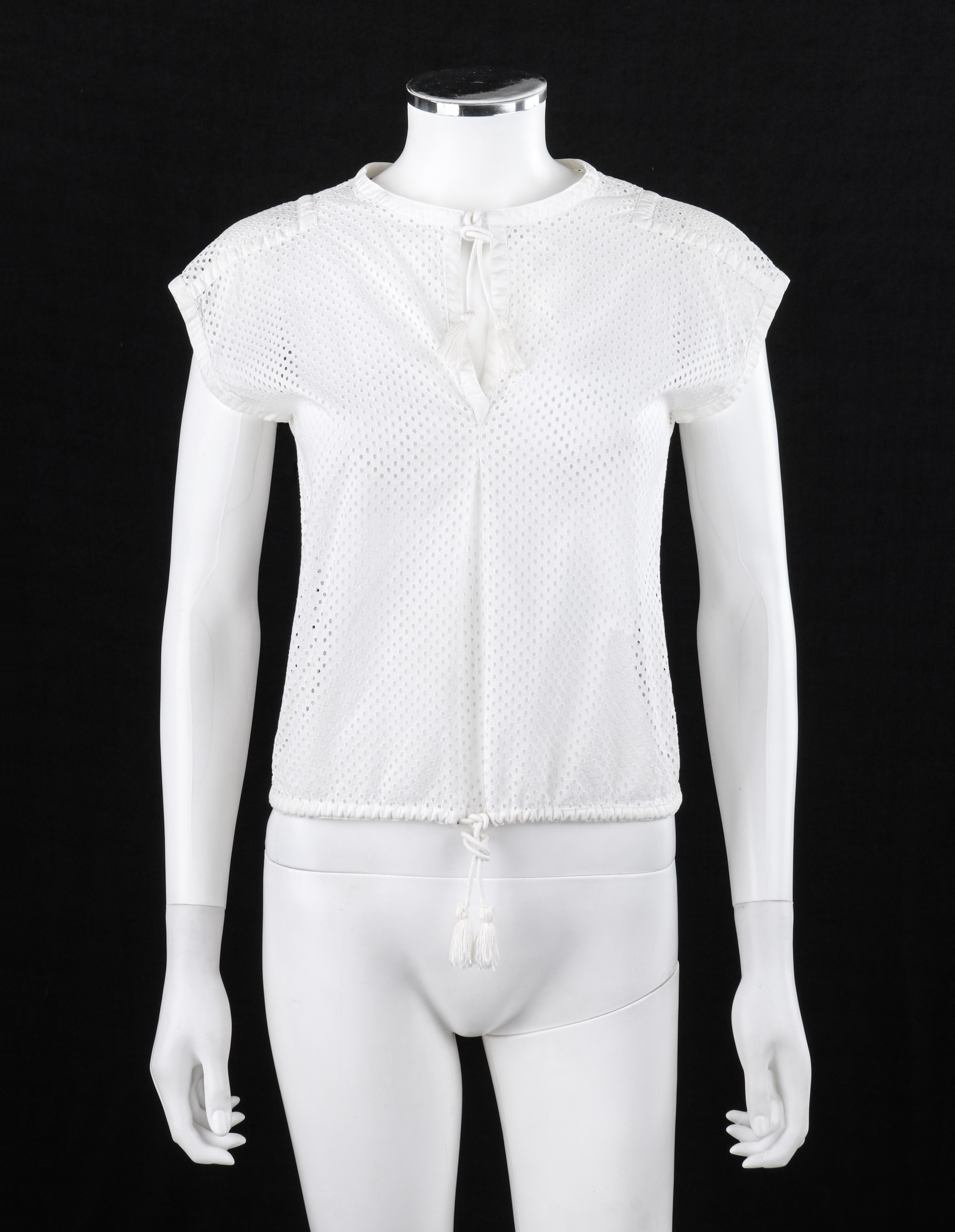 COURREGES c.1980's Epaule étendue White Circle Eyelet Embroidered Tassel Drawstring Top 
 
Marque / Fabricant : Courreges 
Circas : années 1980
Style : Chemise sans manches / épaule allongée
Couleur(s) : Blanc
Doublée : Non
Contenu du tissu marqué :
