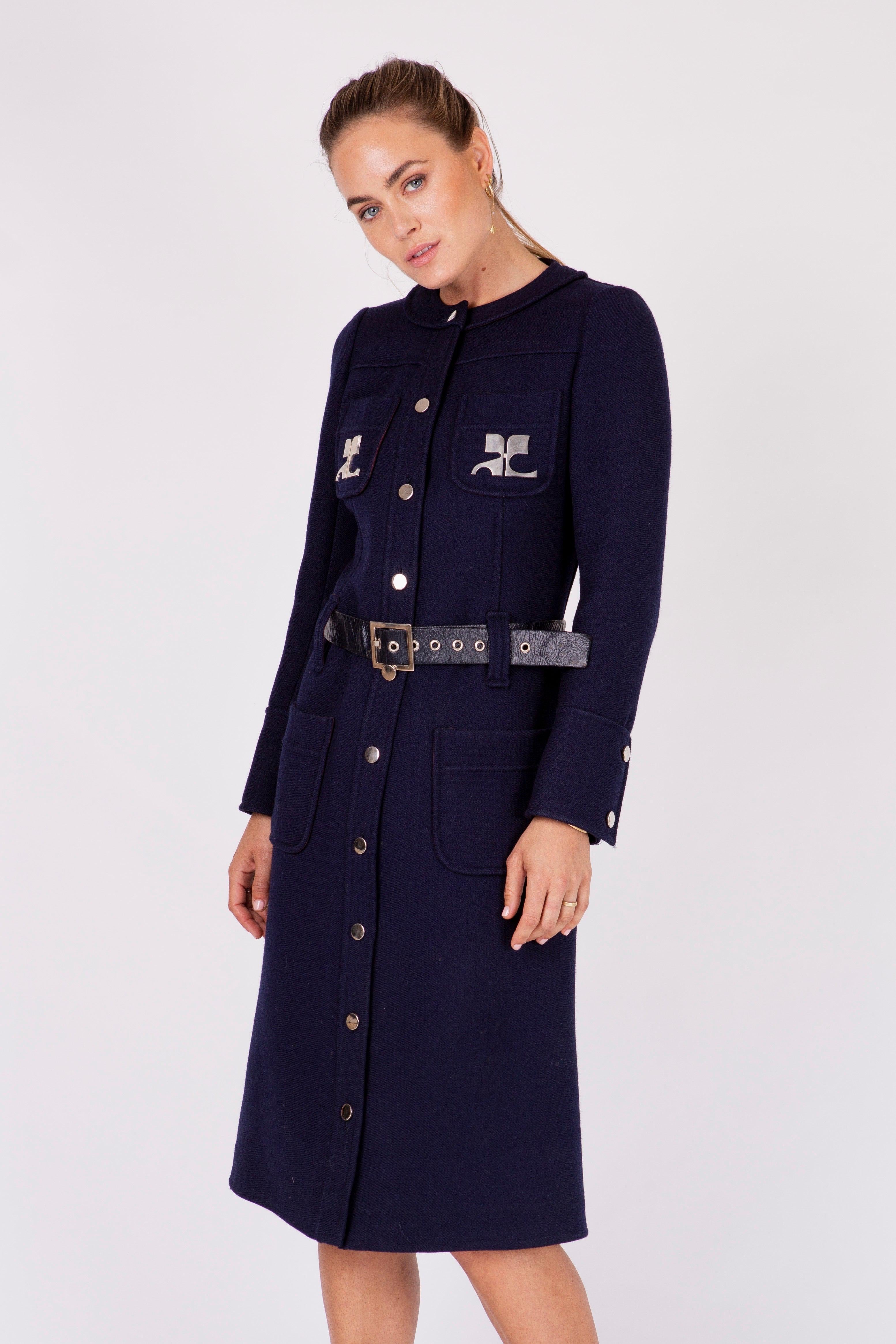 Dating to the 60's, this incredible Courreges coat is a numbered couture piece made of navy wool with two large silver metal logos on each breast pocket, a vinyl belt and silver buttons & belt hardware. Extremely heavy & substantial, this is