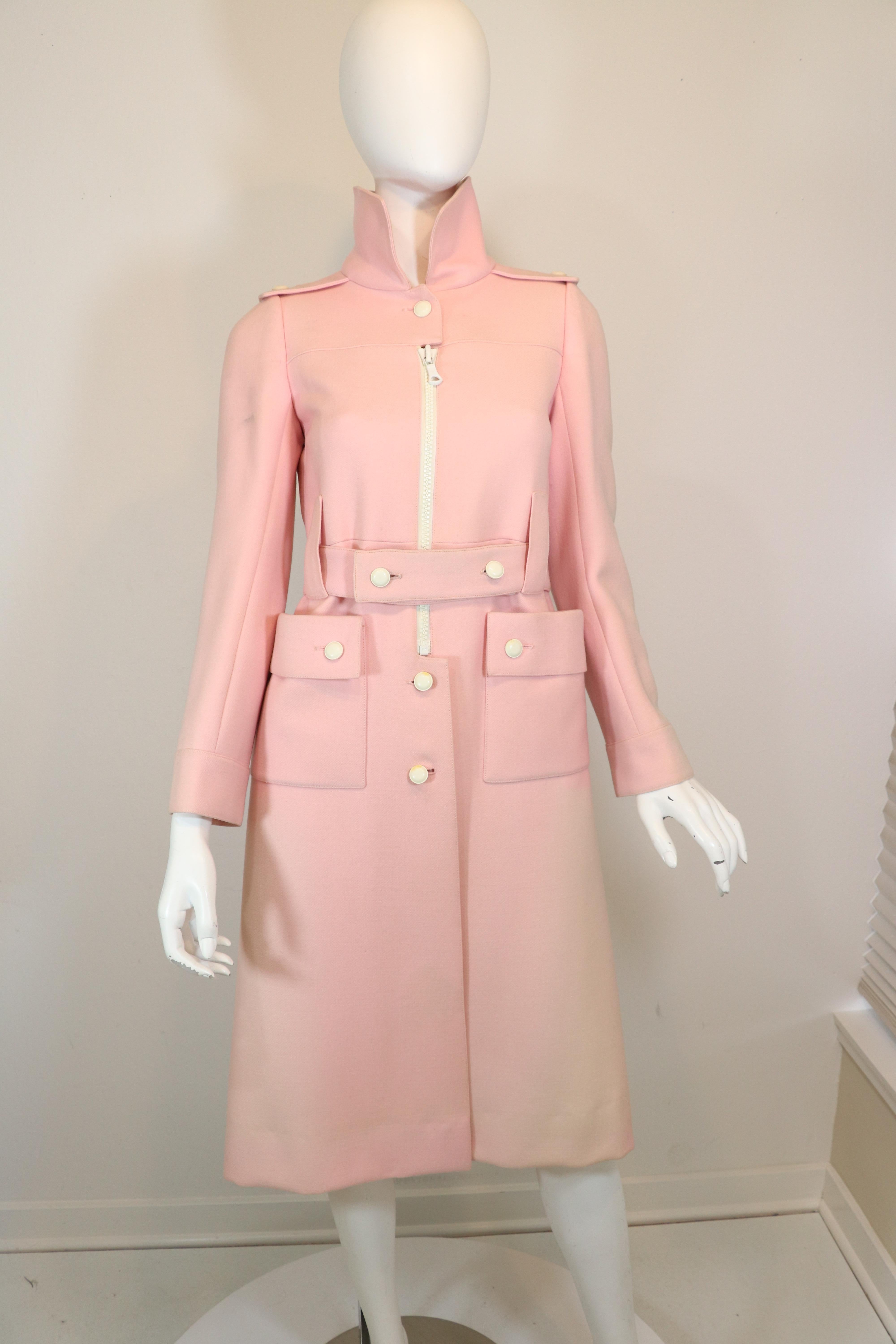 Courreges Couture Future vintage coat from the 1970's: Pink with white embellishments; a white half zippered front, white buttons. Coat has a belt with two white button fastenings. Coat features two front pockets. Fade to fabric down sides, spots