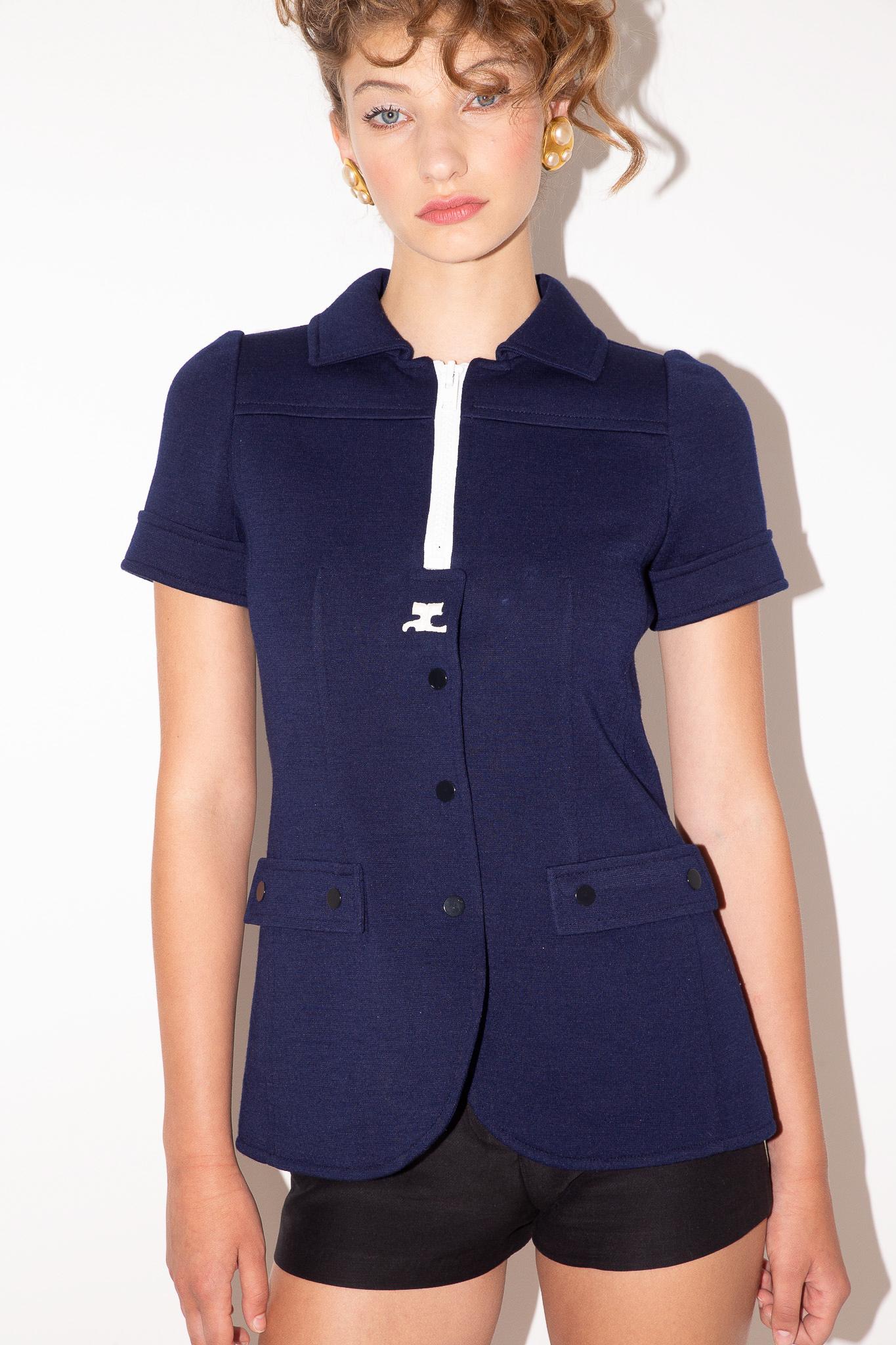 Dating to the 70's, this Courreges top was produced under the Hyperbole label and is individually numbered on the tag. Rendered in a classic navy colourway, it is collared with cuffed sleeves, black snap closures and a chunky white zipper and