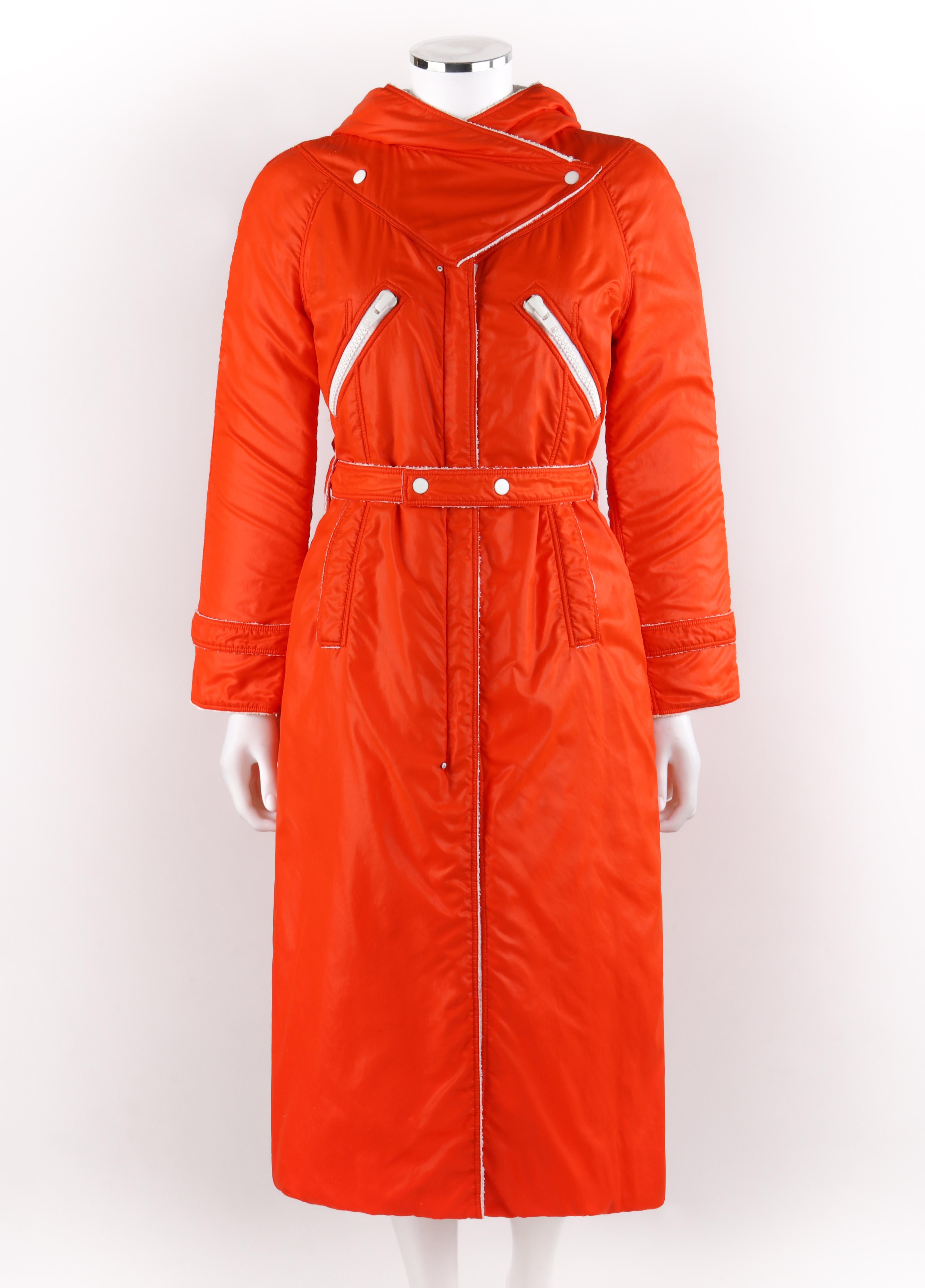 COURREGES Hyperbole c.1970's Manteau long ceinturé à capuche orange
 
Circa : 1970's
Étiquette(s) : Courreges Paris, Hyperbole
Concepteur : Andre Courreges
Style : Manteau 
Couleur(s) : Orange (extérieur) ; nuances de blanc (extérieur, intérieur,
