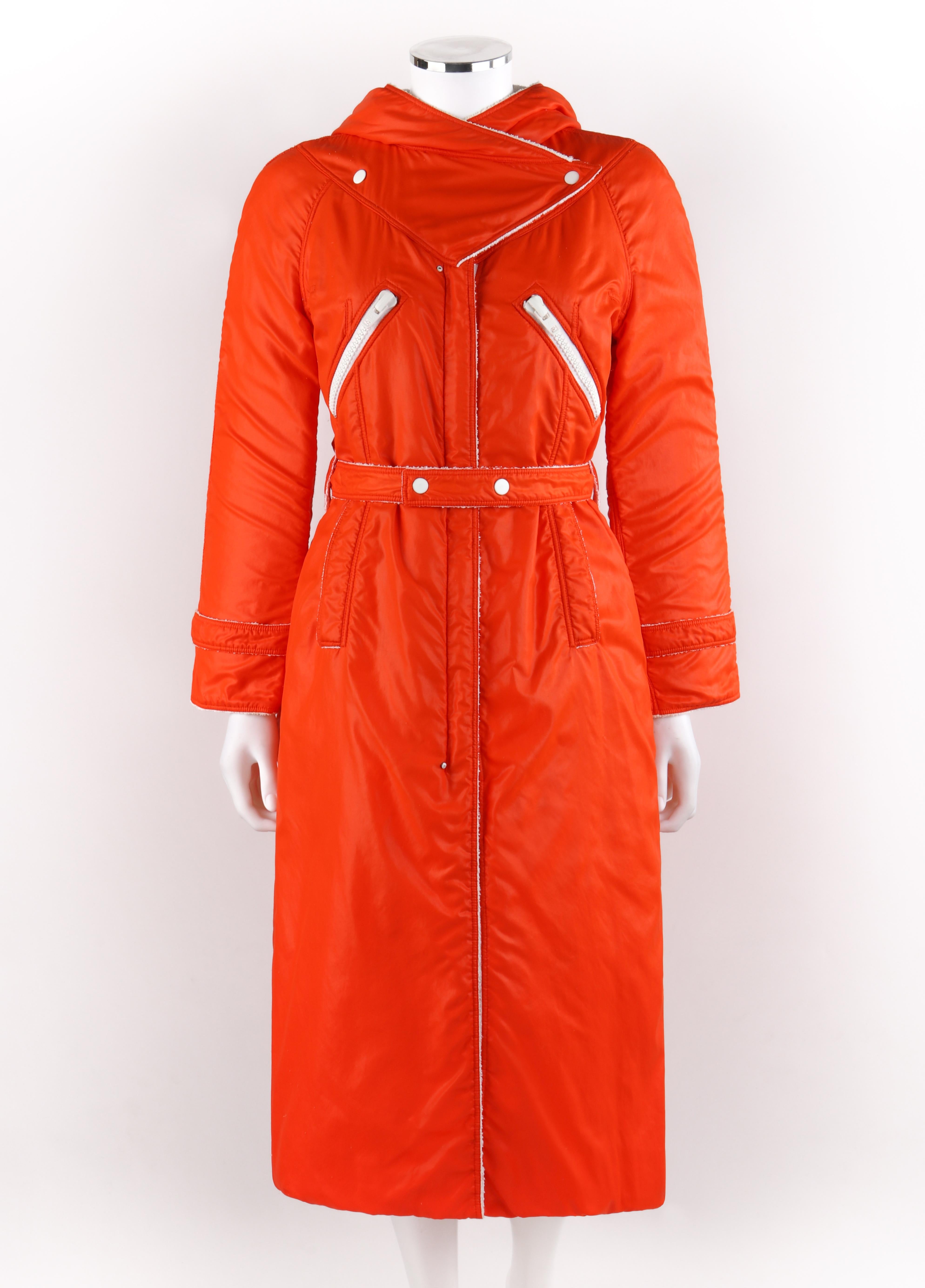 COURREGES Hyperbole c.1970's Orange Hooded Belted Full-Length Coat
 
Circa: 1970’s
Label(s): Courreges Paris, Hyperbole
Designer: Andre Courreges
Style: Coat 
Color(s): Orange (exterior); shades of white (exterior, interior, hardware)
Lined: