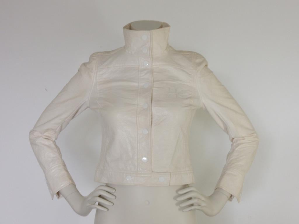 This iconic white on white vintage Andre Courreges jacket has snaps up the front and a stovepipe collar. The cropped fit makes this wonderful jacket completely relevant and current. 

The condition is only fair, however. There is reddish staining on