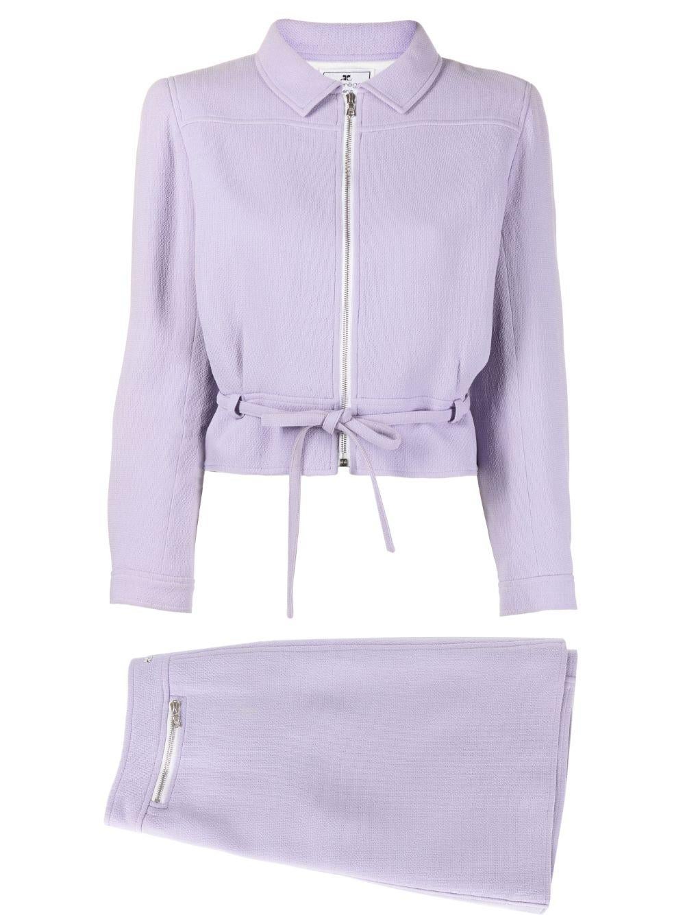 Andre Courreges lilac suit jacket and skirt featuring tie-waist jacket with detachable belt, front zip opening, long sleeves, press-stud fastening cuffs and an ivory lining. 
Skirt featuring a A-line, an above-knee length, a center logo, a front zip