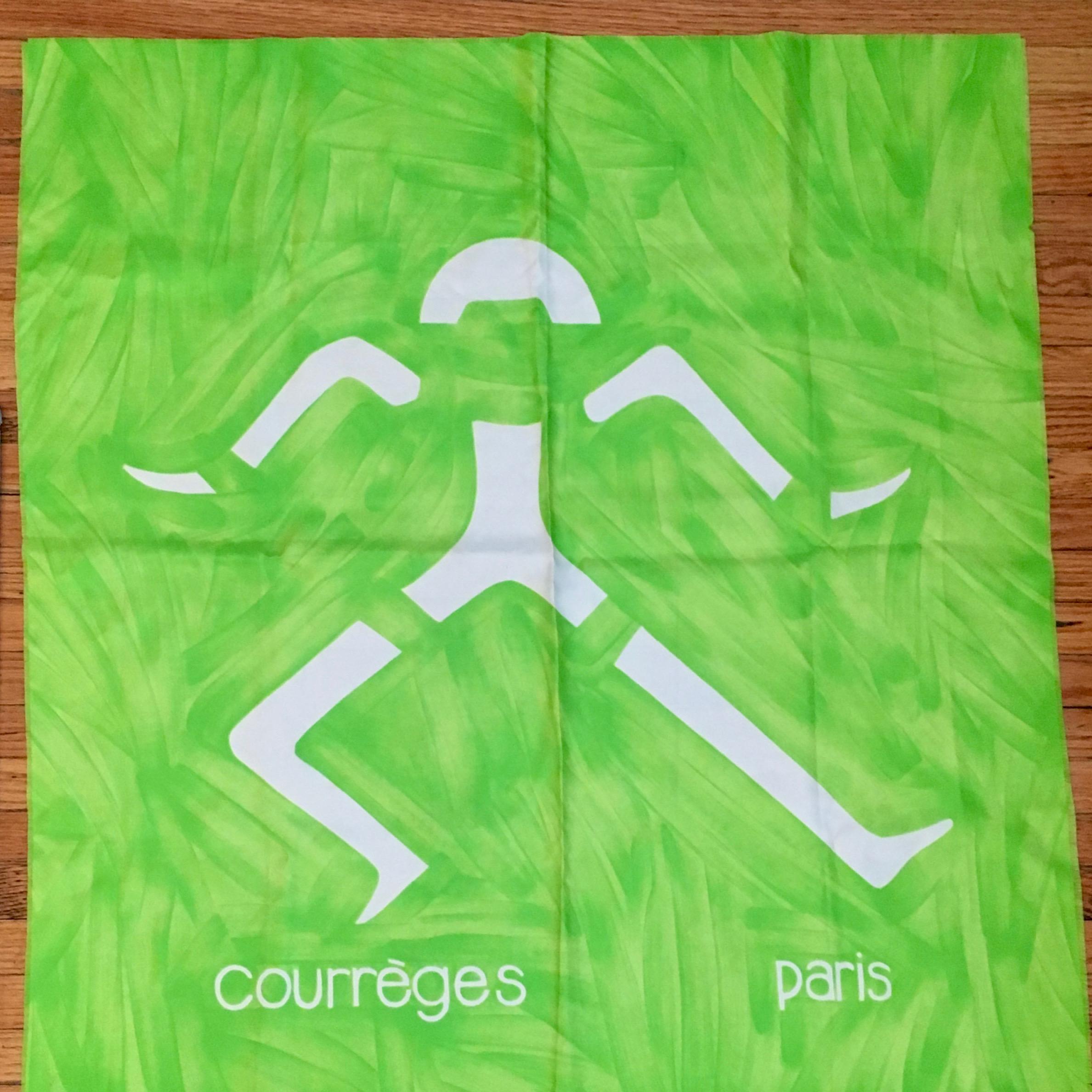 This is an amazing neon green Courreges scarf from the 1960s. The green background features what looks like brush strokes. The design features an abstract dancing man in the center with 'Courreges Paris' written under it. There is no content tag on