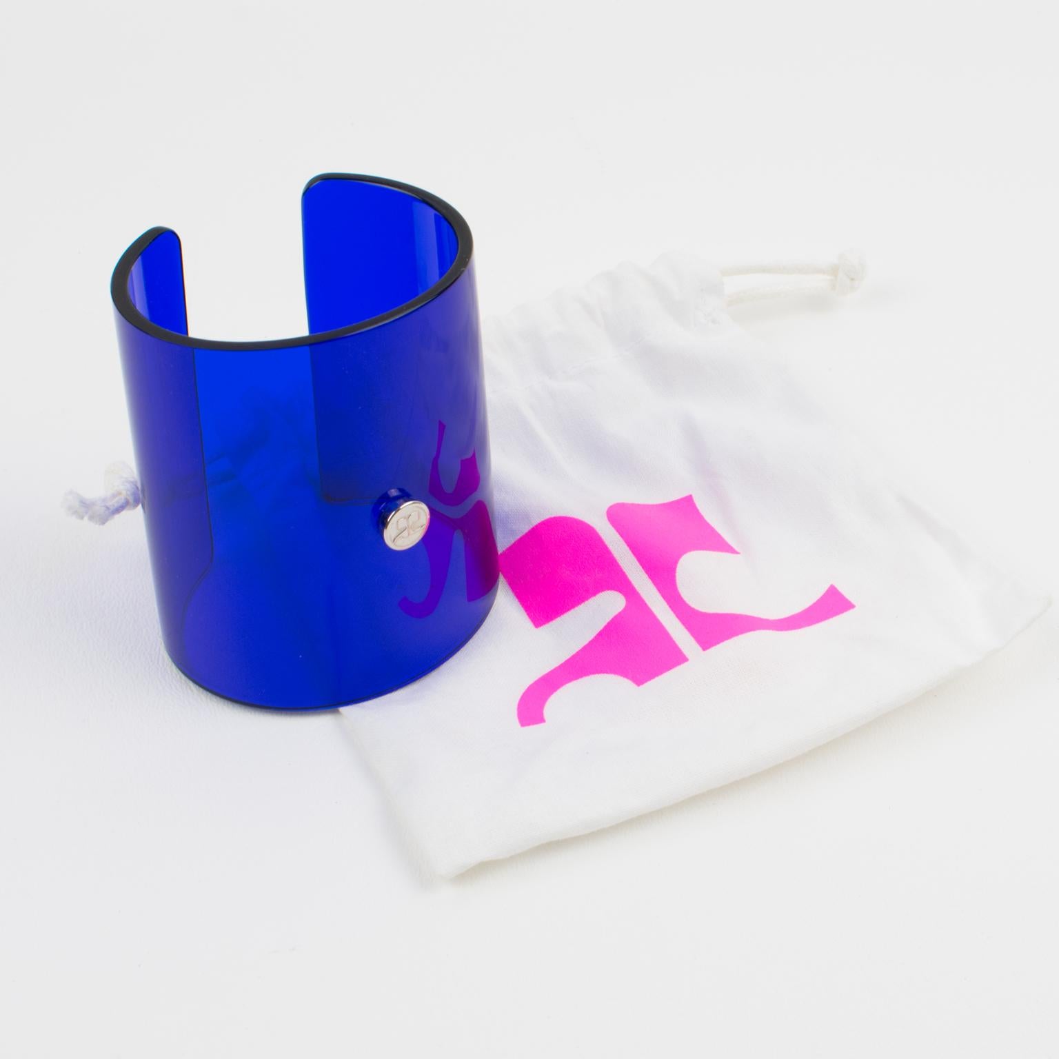 This adorable Courreges Paris signed Lucite or acrylic bangle bracelet features an oversized cuff design in a transparent cobalt blue color with a cone shape. The piece is signed on the front with the chromed metal AC, Courrege's iconic brand logo.
