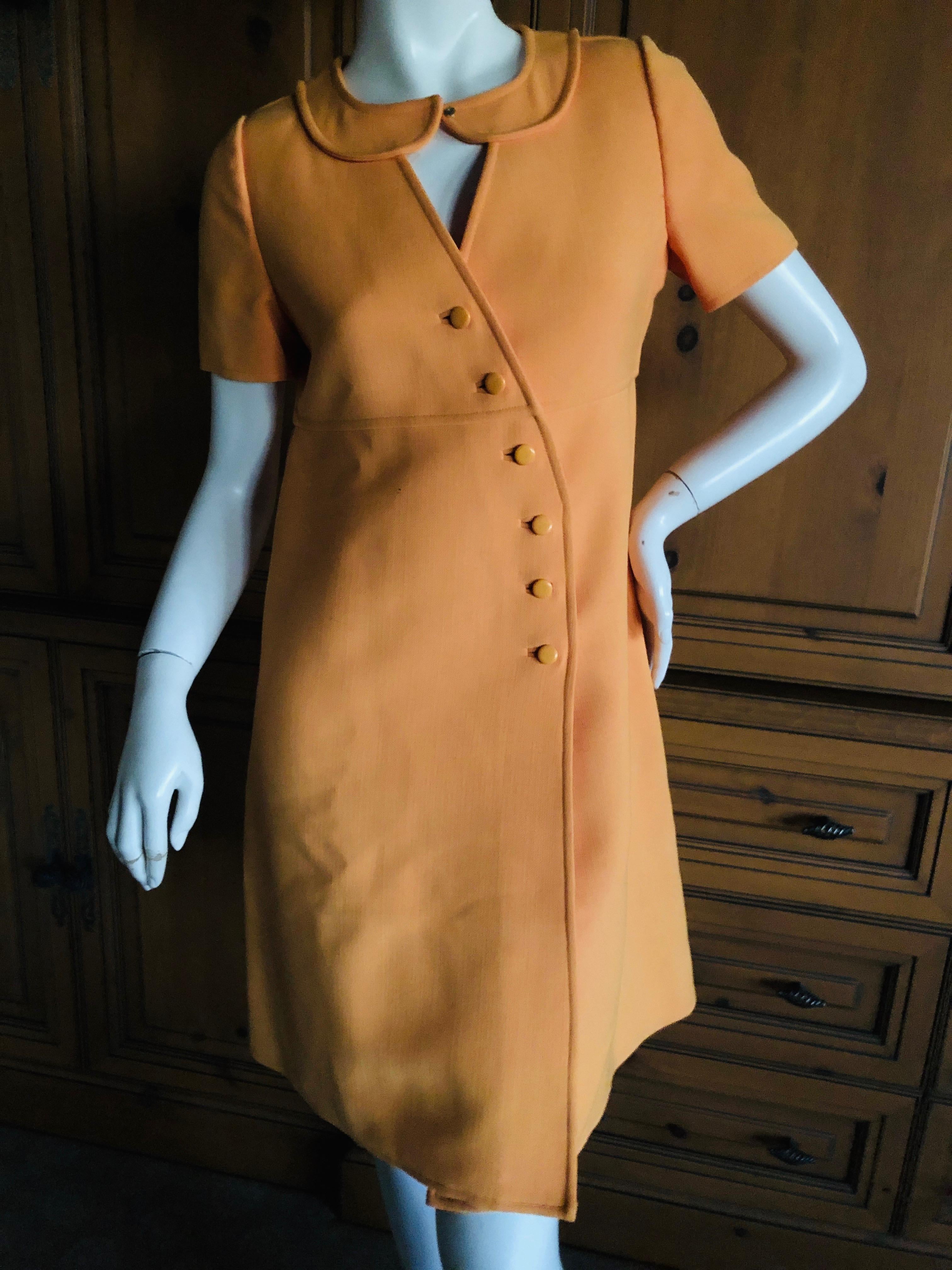 Courreges Paris Couture Future Numbered 1966 Orange Asymmetrical Snap Front Dress.
Courreges was considered very avant guard when he created his first MOD collection, shown with space age looking accessories and white Go Go boots in 1965.
This is