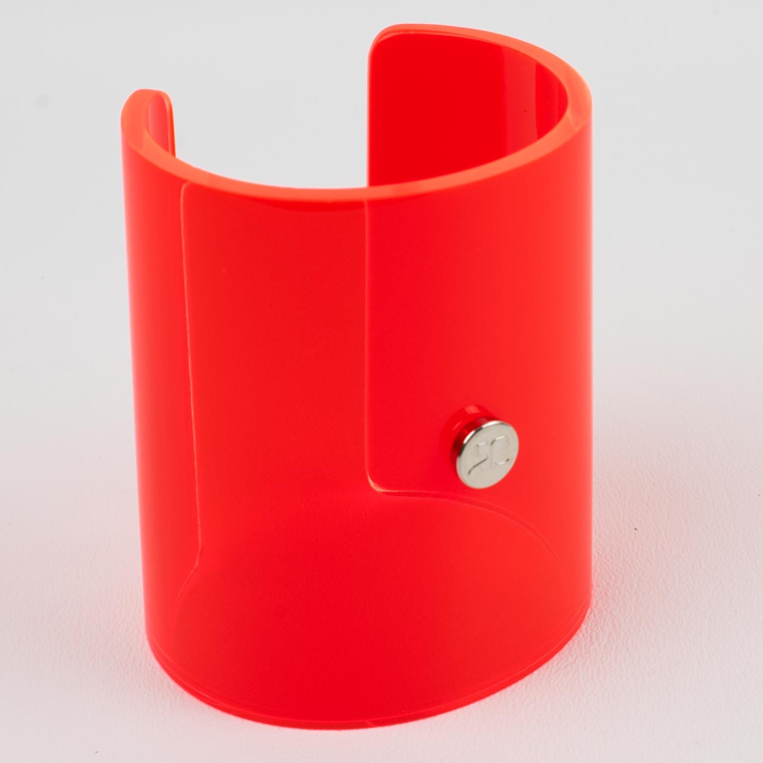 Courreges Paris designed this stunning Lucite or acrylic bangle bracelet. The oversized cuff design has a fully transparent neon orange color with a cone shape. The color is unusual and glows in the dark. The cuff is signed on the front with the