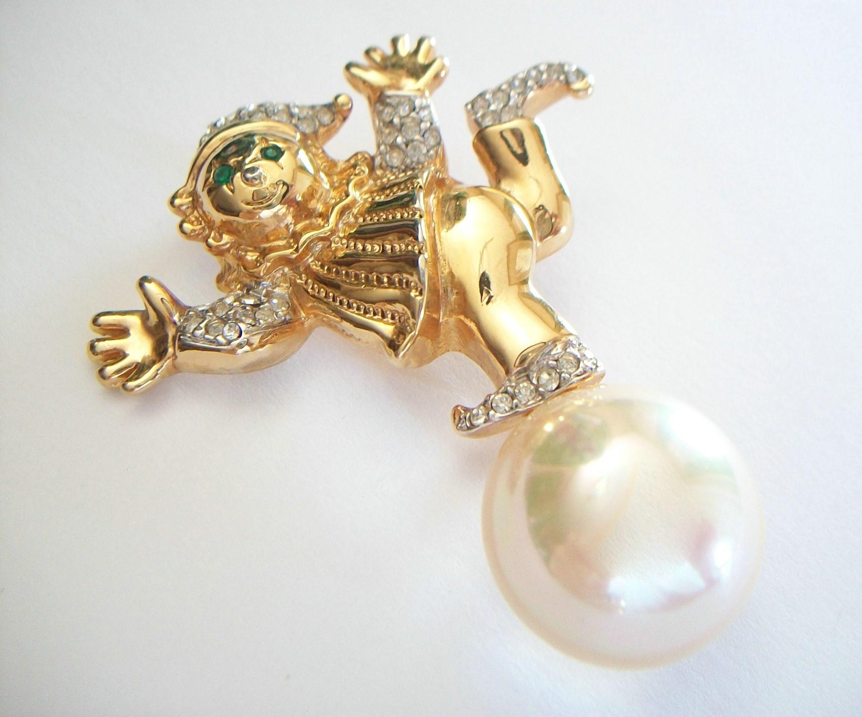 Courrèges Paris - Vintage whimsical faux Mabe pearl brooch - featuring a balancing figure on a ball - yellow gold tone body - white gold tone shoes, cuffs and hat set with rhinestones - original pin with safety catch to the back - signed - France -