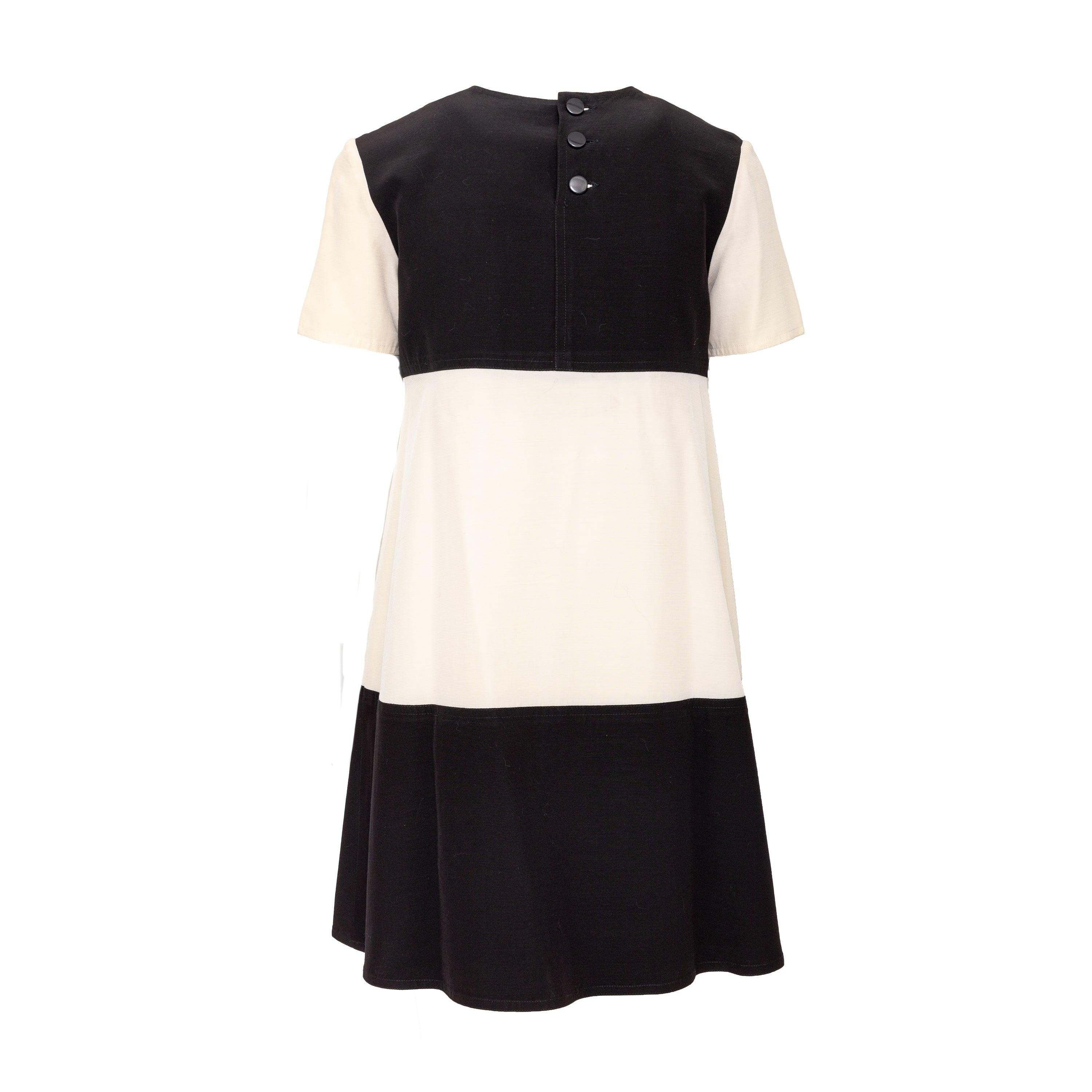 Dieses Midikleid im Vintage-Stil von Courrèges besticht durch ein verspieltes und gewagtes Colorblock-Design mit breiten, kontrastierenden Streifen. Die Besonderheit ist der runde Ausschnitt auf der Vorderseite, der ein einzigartiges und auffälliges