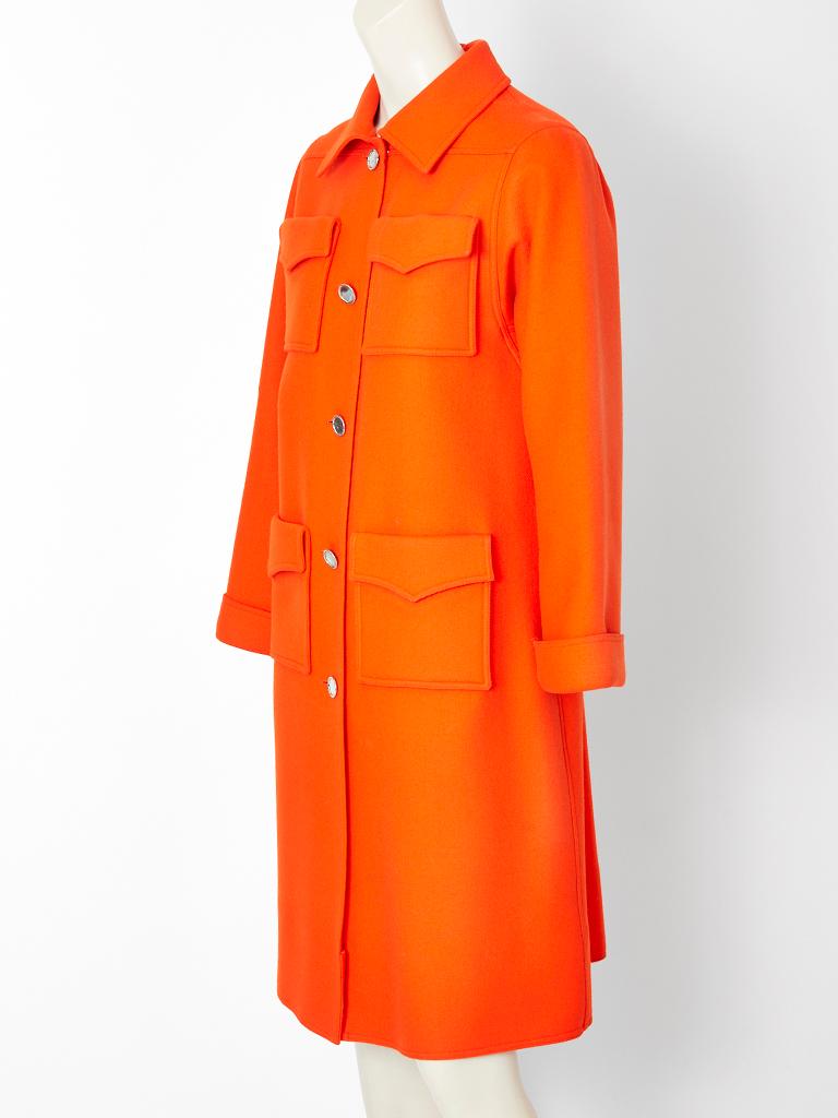Courregès,  bright orange, unlined, wool twill coat, having a pointed collar, 4 patch pockets at the bust and hips and welted seam details. 