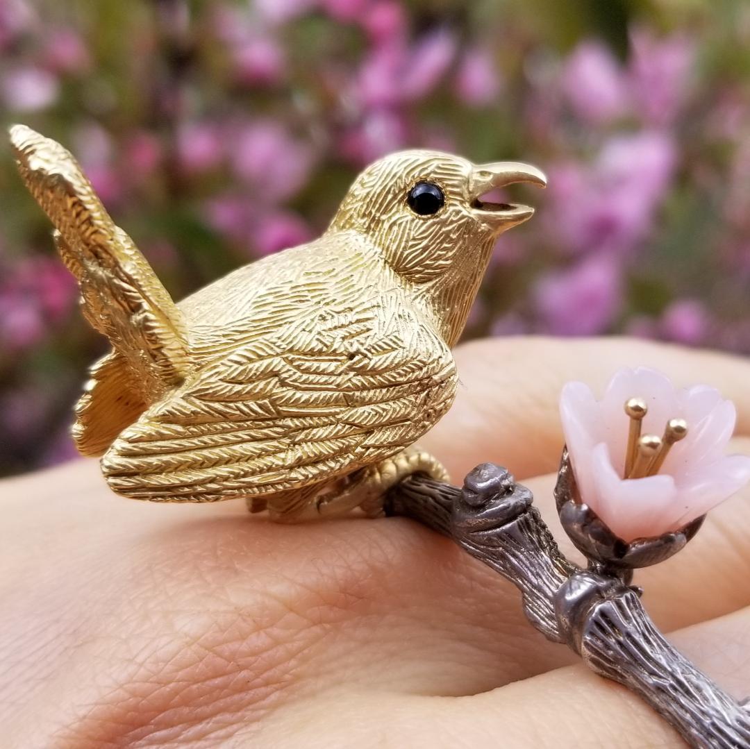 This handsome little guy sings a love song for his beloved.
The wren was hand-carved in two parts by New York artist Manya Tessler and cast in 18k recycled yellow gold. The two parts were then assembled and hand-engraved in New York city, where the