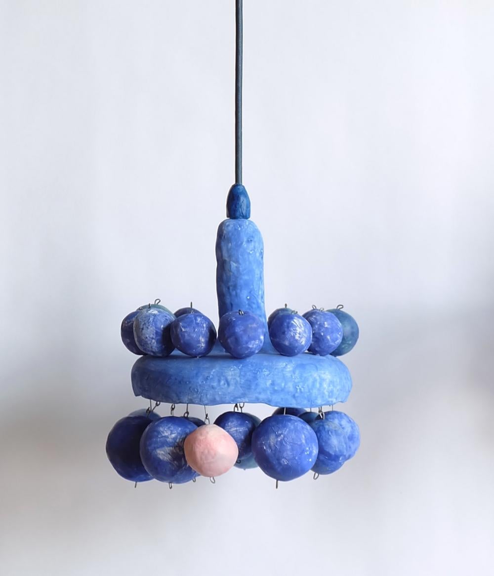 Oo is a hand-built ceramic pendant lamp from the Courtship Behavior, a project inspired by the curious behavior of the Satin Bowerbird, the eastern Australian birds known for decorating their nests with objects they collect to attract a mate. The