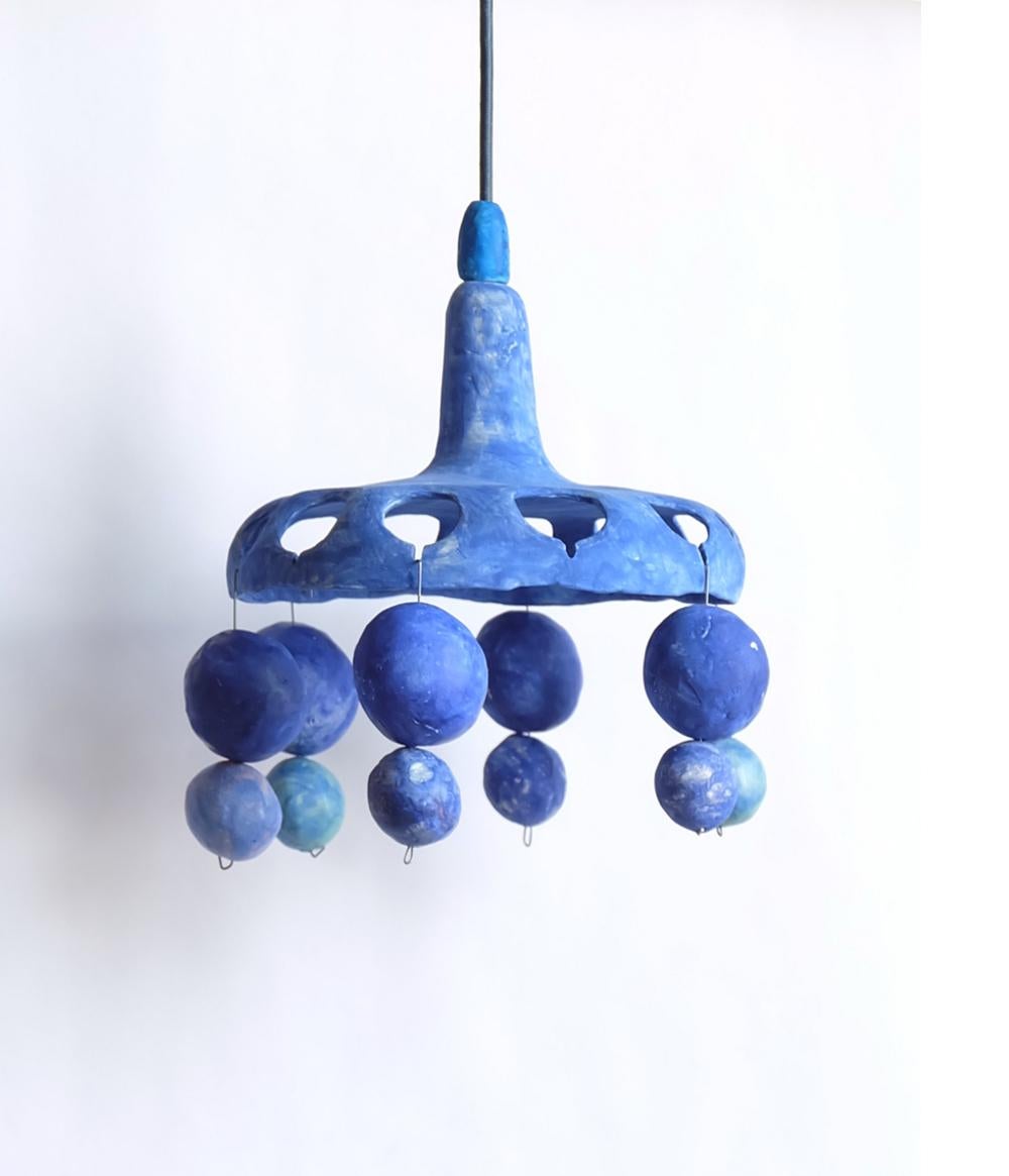 Wee is a hand-built ceramic pendant lamp from the Courtship Behavior, a project inspired by the curious behavior of the Satin Bowerbird, the eastern Australian birds known for decorating their nests with objects they collect to attract a mate. The