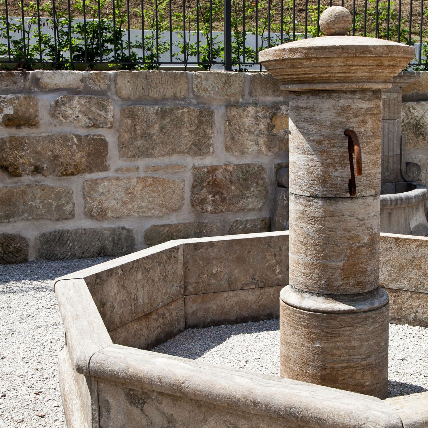 Large fountain out of bluestone with an octagonal basin and a round central column. The column has four spouts and has a ball crowning. 
Height of basin: 60 cm
Size of column: H: 200 cm x Ø80 cm.