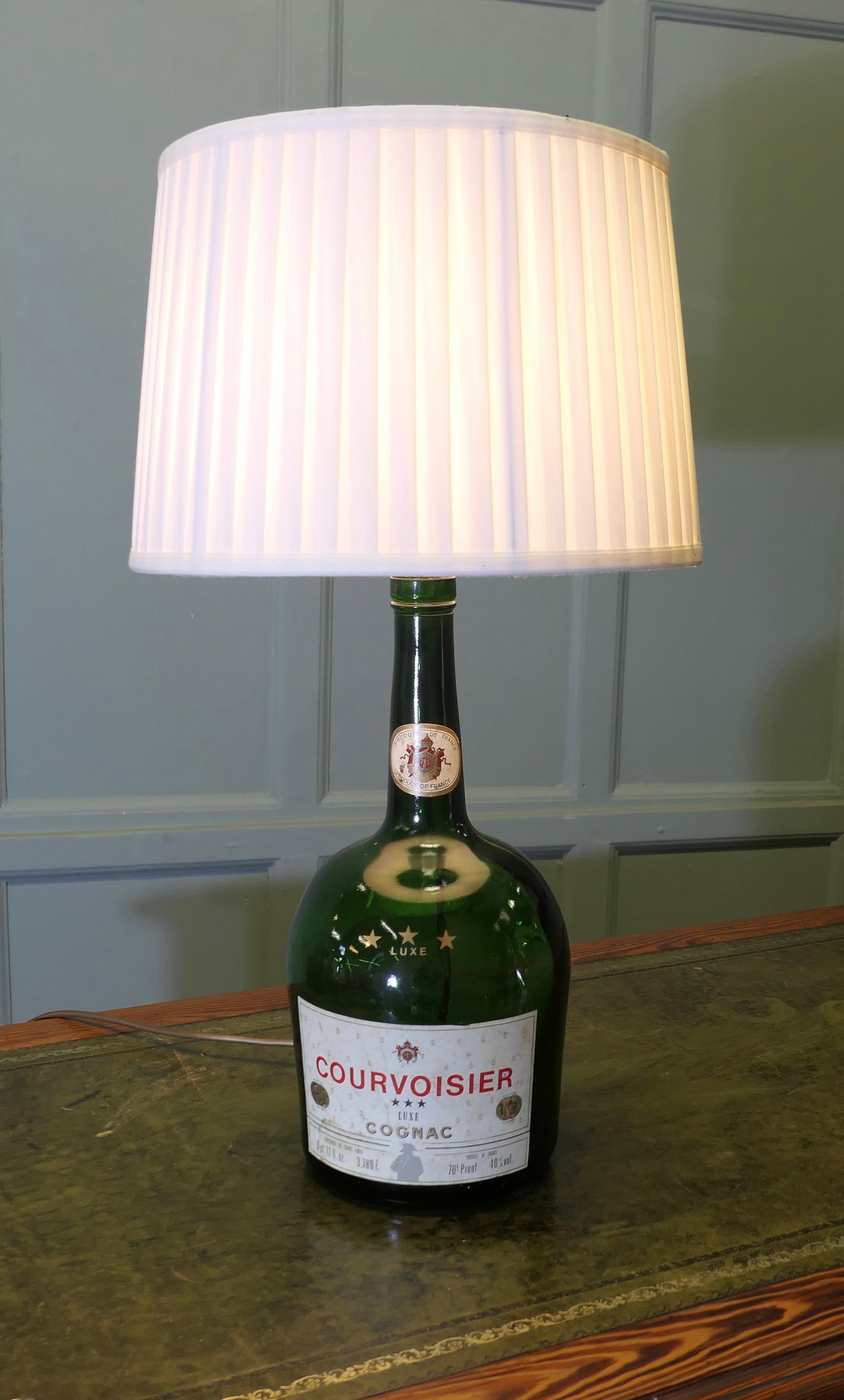Lampe à poser publicitaire Courvoisier 3 Star Luxe Cognac
Tout juste arrivée de France, cette superbe lampe faisait partie d'un présentoir publicitaire. Il s'agit d'une véritable bouteille de 3,78 litres, accompagnée de son abat-jour plissé.
Le