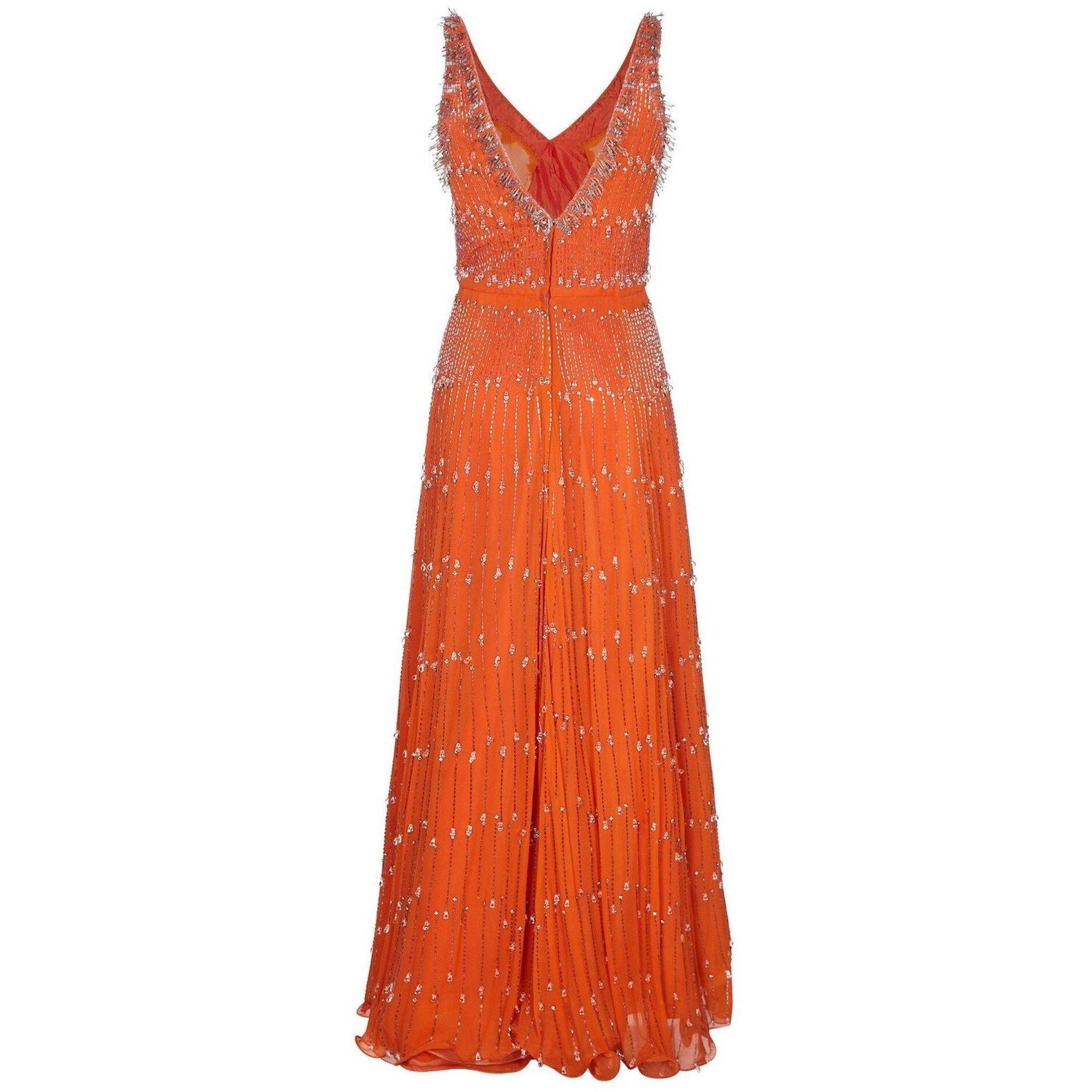 This magnificent late 1960s silk chiffon beaded gown exudes haute couture quality and is in excellent vintage condition. The burnt orange silk chiffon overlay showcases some fabulous crystal embellishment. Silver-toned bugle beads are arranged to