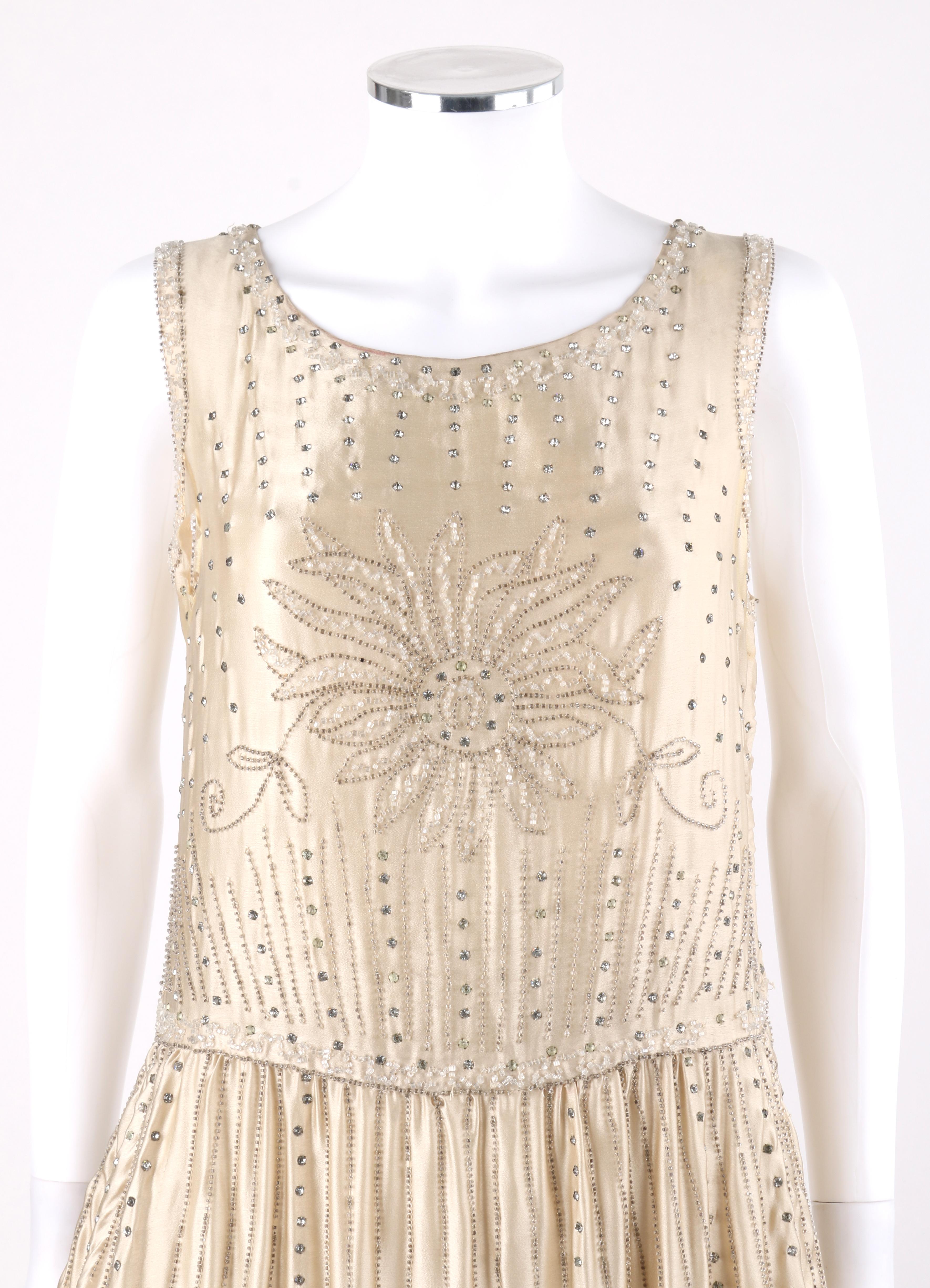 COUTURE c.1920's Einzigartige Champagner Seide Blumen Glas Perlen Strass Flapper Kleid 

CIRCA: 1920er Jahre
Stil: Flapper Dress
Farbe(n): Champagner 
Gefüttert: Nein 
Unmarkiert Stoffinhalt: Seide  
Zusätzliche Details / Einschlüsse: Ärmelloses