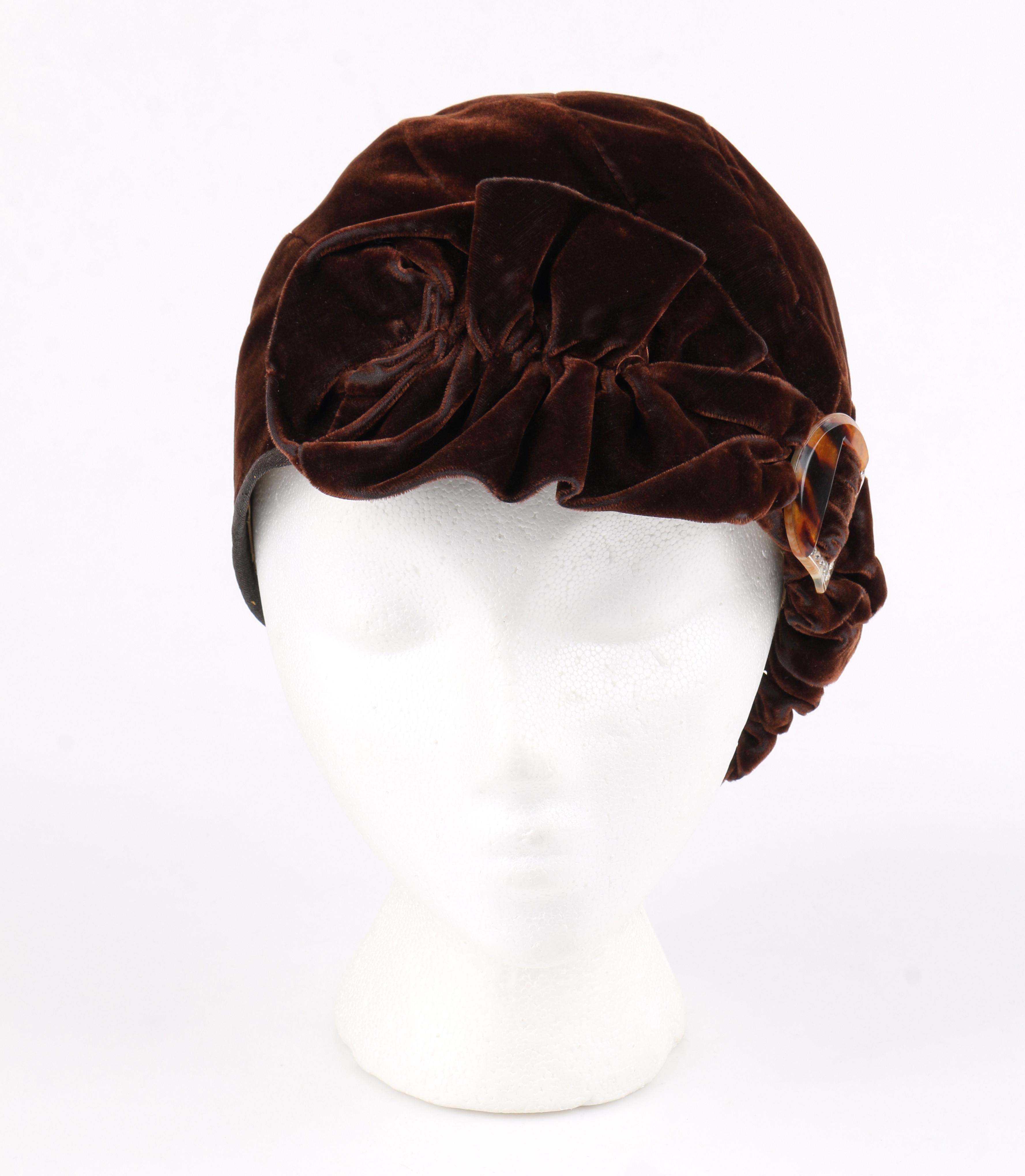 COUTURE c.1920’s Dark Brown Ruffle Tortoise Shell Crystal Deco Embellishment Velvet Cloche Hat
 
Circa: 1920’s 
Style: Hat
Color(s): Brown
Lined: Yes 
Unmarked Fabric Content (feel of): velvet (exterior); silk (lining)
Additional Details /