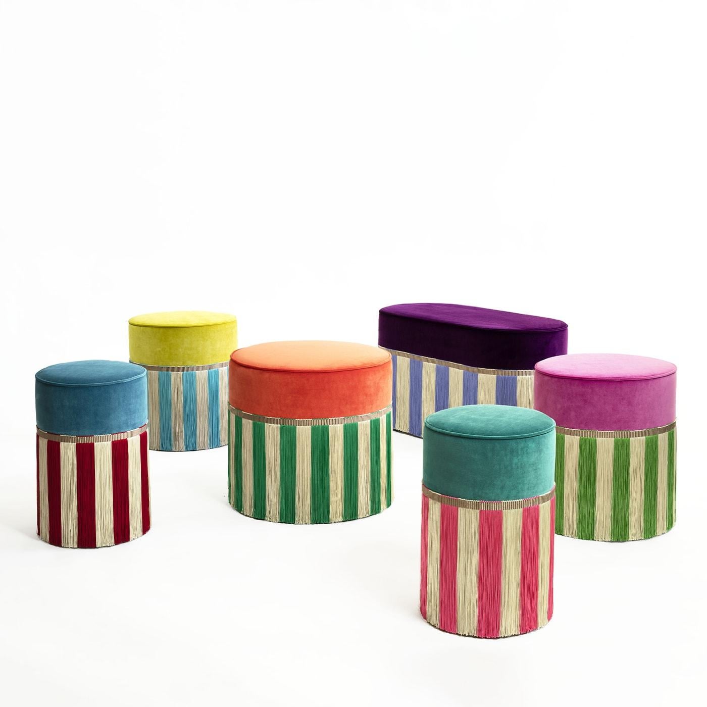 A vibrant turquoise hue was selected for the plush seat of this cylindrical ottoman, a seating solution whose stylish appeal is sealed by the striped design of its viscose fringes outlining a pink and white striped design. The sturdy beech core