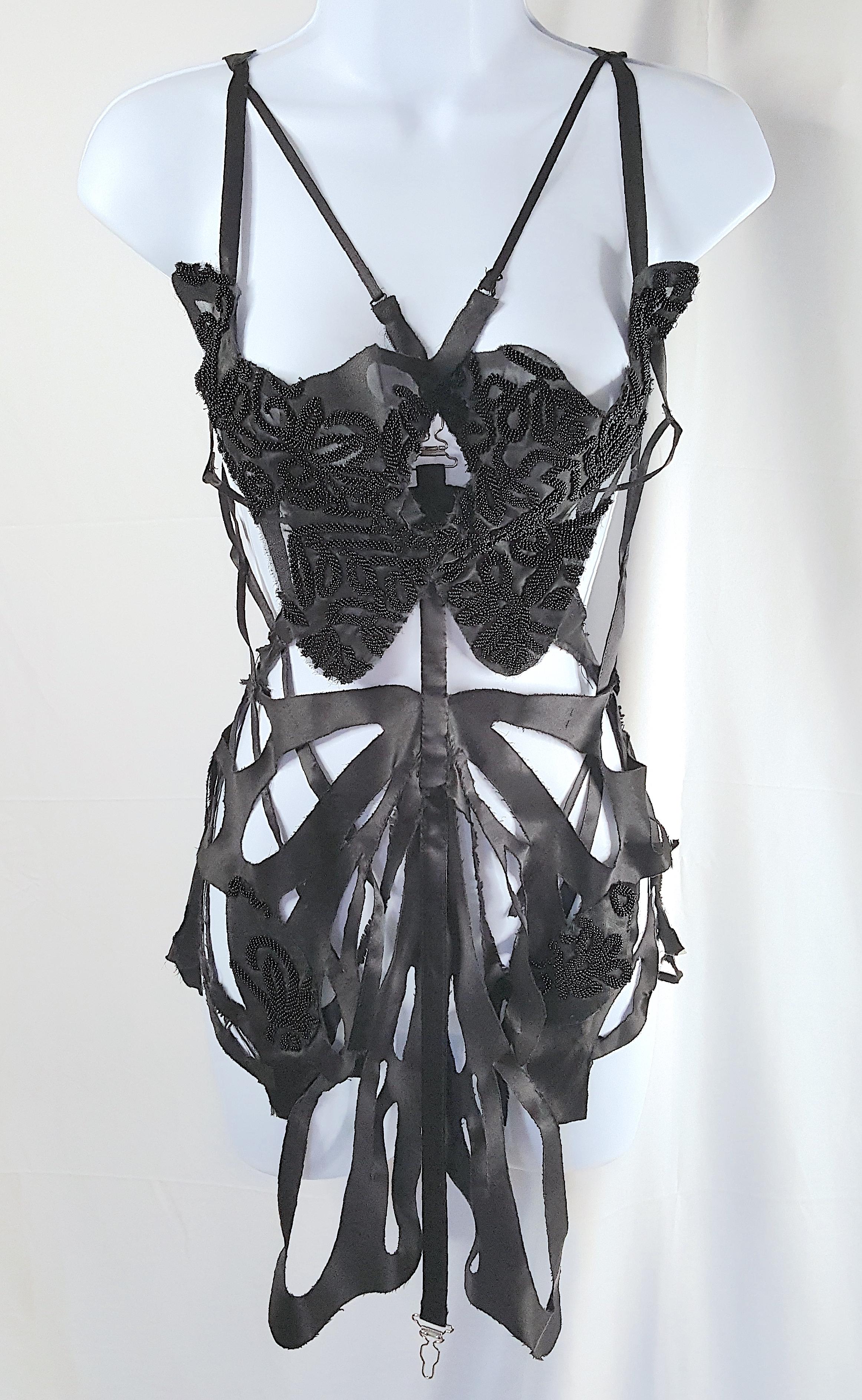 This couture lingerie-like spaghetti-strapped black silk satin apron vest, with extraordinary graphic cutwork featuring a heavily hand-beaded breast-plate and appliques, was custom made by a young designer for a New York City female client in the