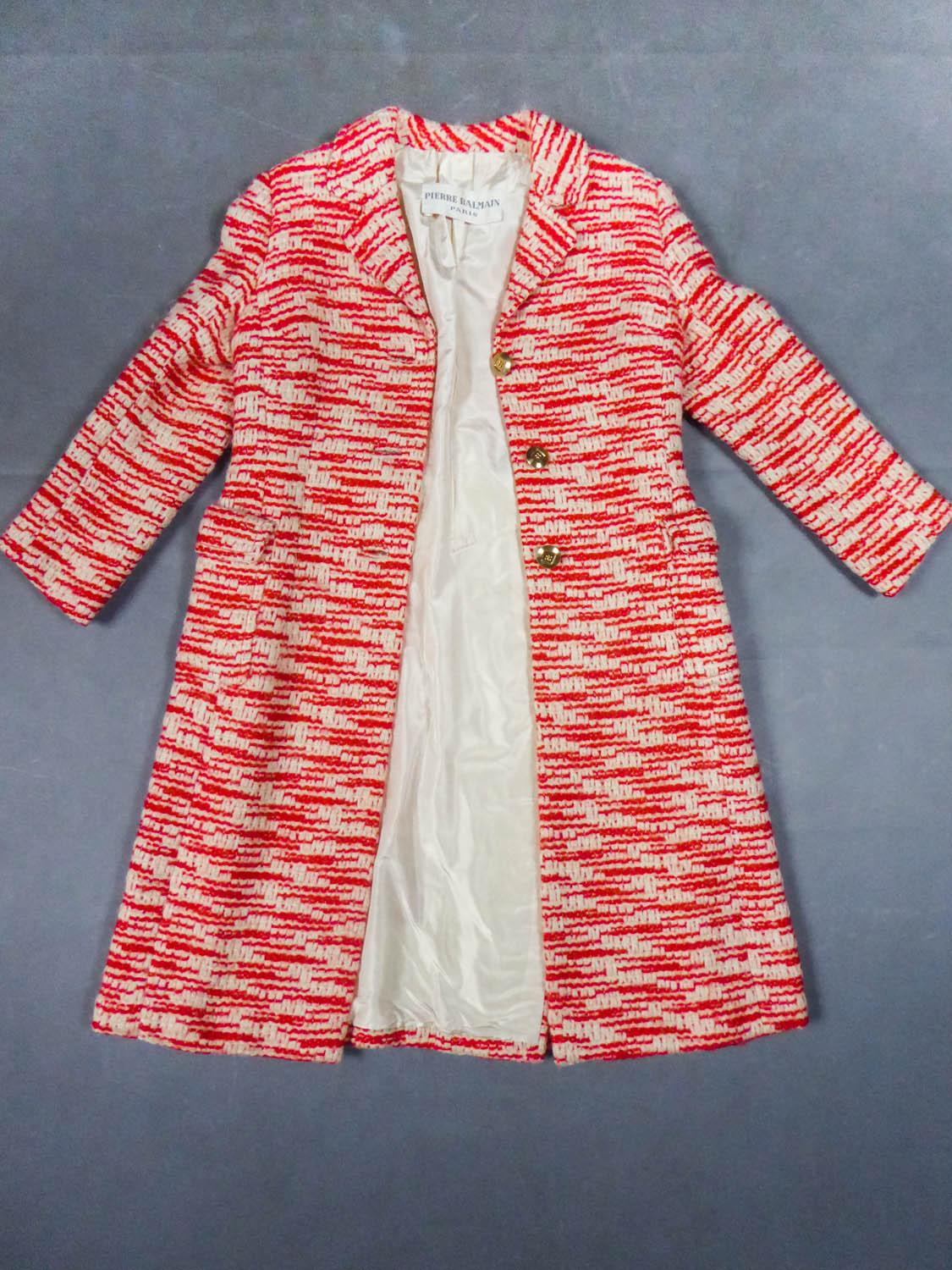 Um 1970
Frankreich

Mantel aus zweifarbiger, rot-weißer Strickwolle mit geometrischen, sich nicht wiederholenden Mustern aus dem berühmten Couture-Designerhaus Pierre Balmain. Große Nähte und taillierter Schnitt mit breitem, leicht ausgestelltem