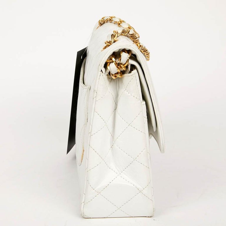 Classic and timeless, this vintage CHANEL bag is in white lambskin leather. The jewelry is in gold metal and the clasp is two-tone, gold and silver metal. 
Worn over the shoulder. Good condition, the corners are no longer colored (see photos). The