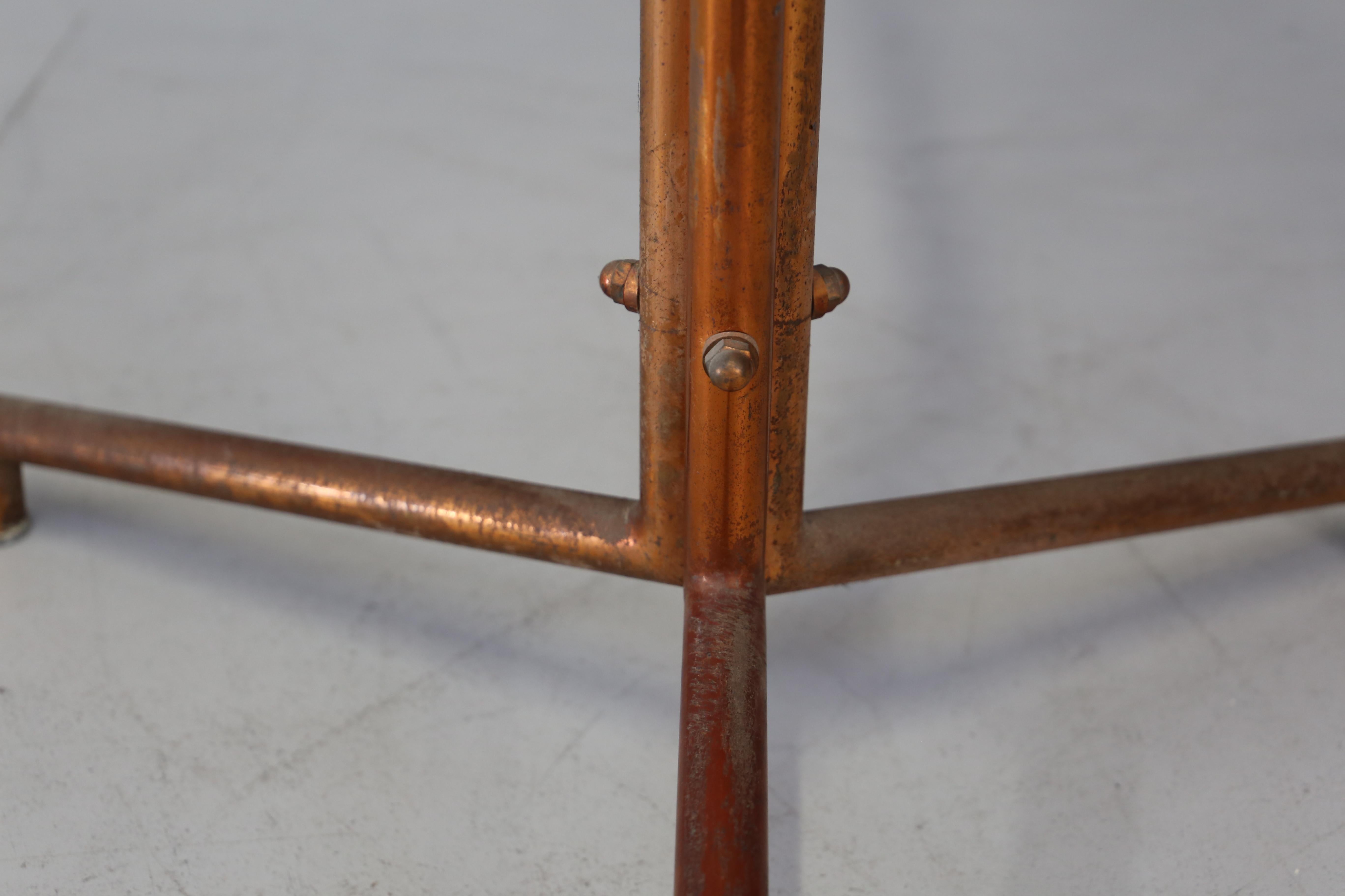 Midcentury clothes hangers for the 1936 Cova factory. The coat rack is made with a tubular steel structure painted copper, its peculiarity is in its branch of the arms with spherical elements in wood. Its tripoidal shape of the base is also