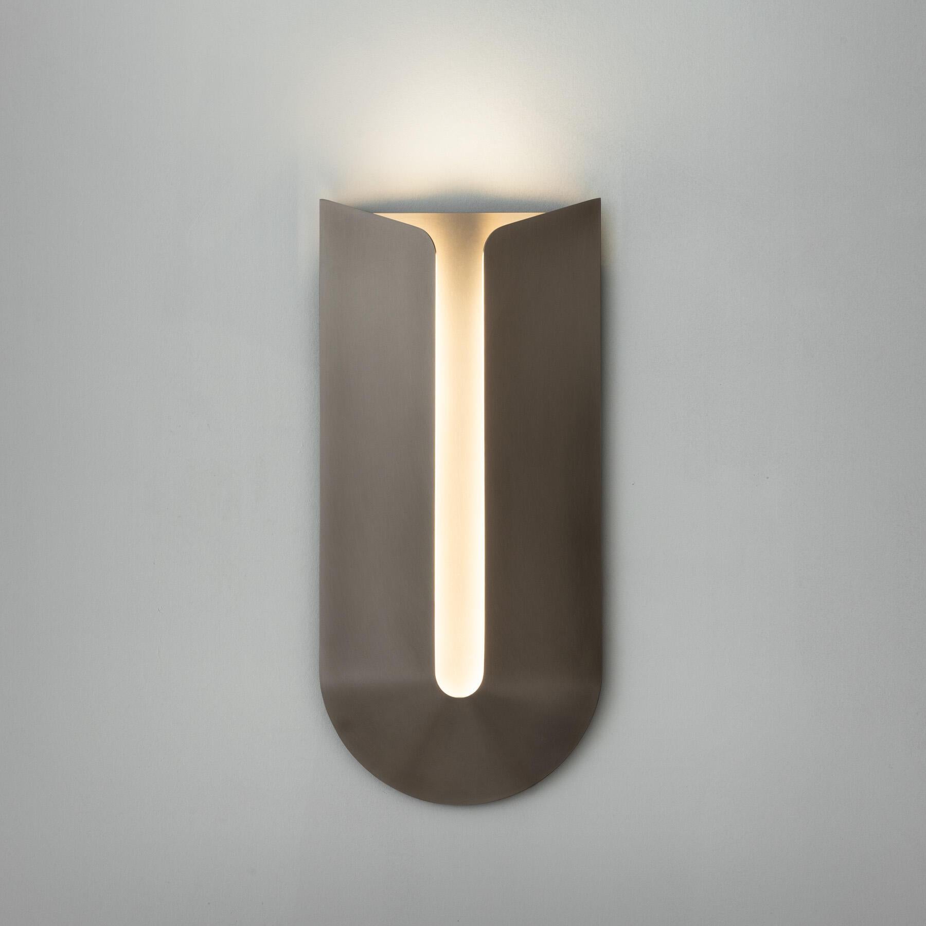 Cove is a low-profile but sizable sconce, with a minimal design that celebrates form and materiality in seemingly endless combinations. Whether mounted to wash light from above or below, the architectural curves of this ADA-compliant piece gently