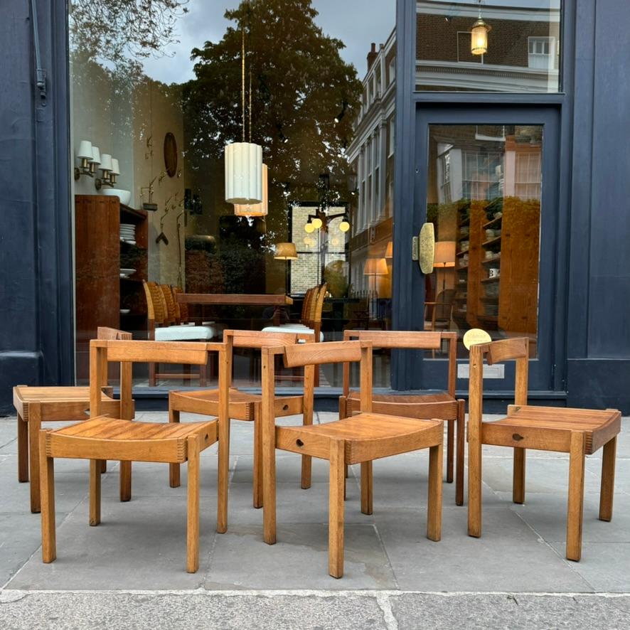 A set of six British oak chairs, designed in 1960 by Dick Russell for the rebuilding of Coventry Cathedral; a post-war project led by Sir Basil Spence following the near total destruction of the cathedral on November 14th, 1940 as part of a raid