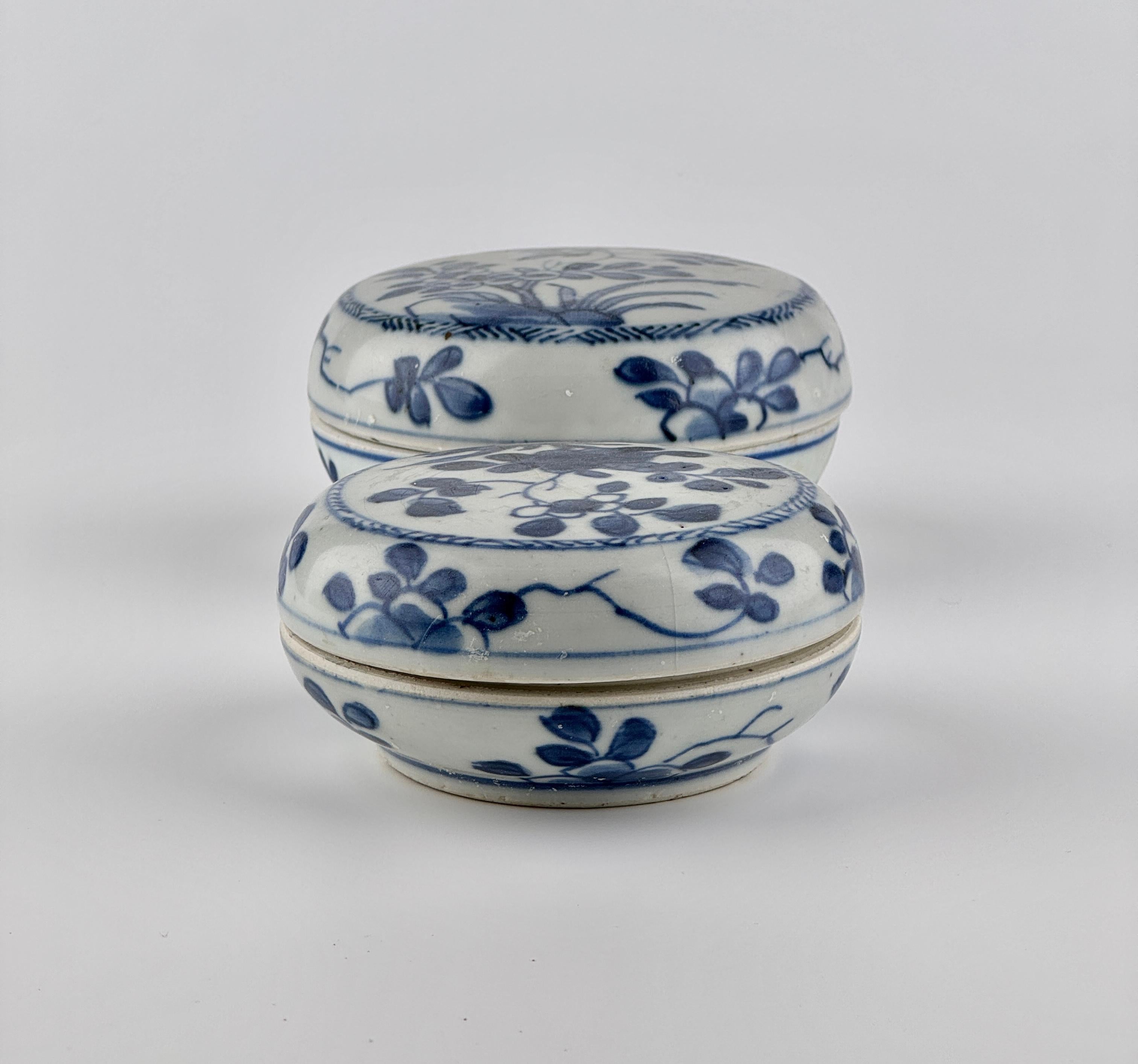The central design features botanical motifs, with fully bloomed flowers and branches intricately depicted. The rim of the lid is encircled by a decorative band resembling a twisted rope, while the body of the vessel is adorned with a scattered