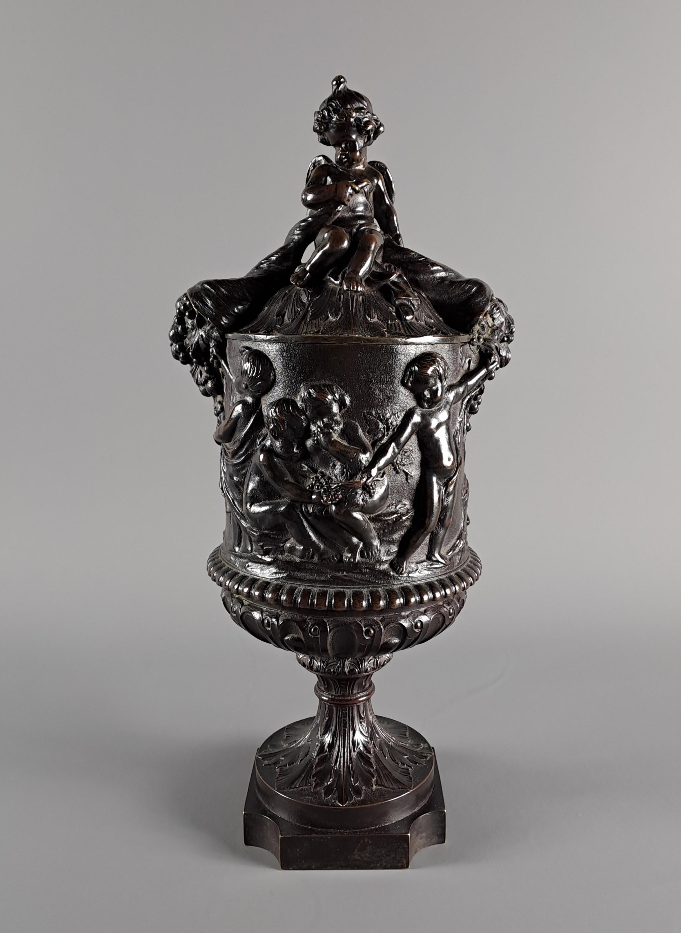 Superbe vase couvert en bronze à patine brune décoré de bacchanales, de putti et de cornes d'abondance autour des symboles du vin et de la vigne.

Beau travail de ciselure, sans doute issu des ateliers d'un bronzier parisien du XIXe siècle.

Très