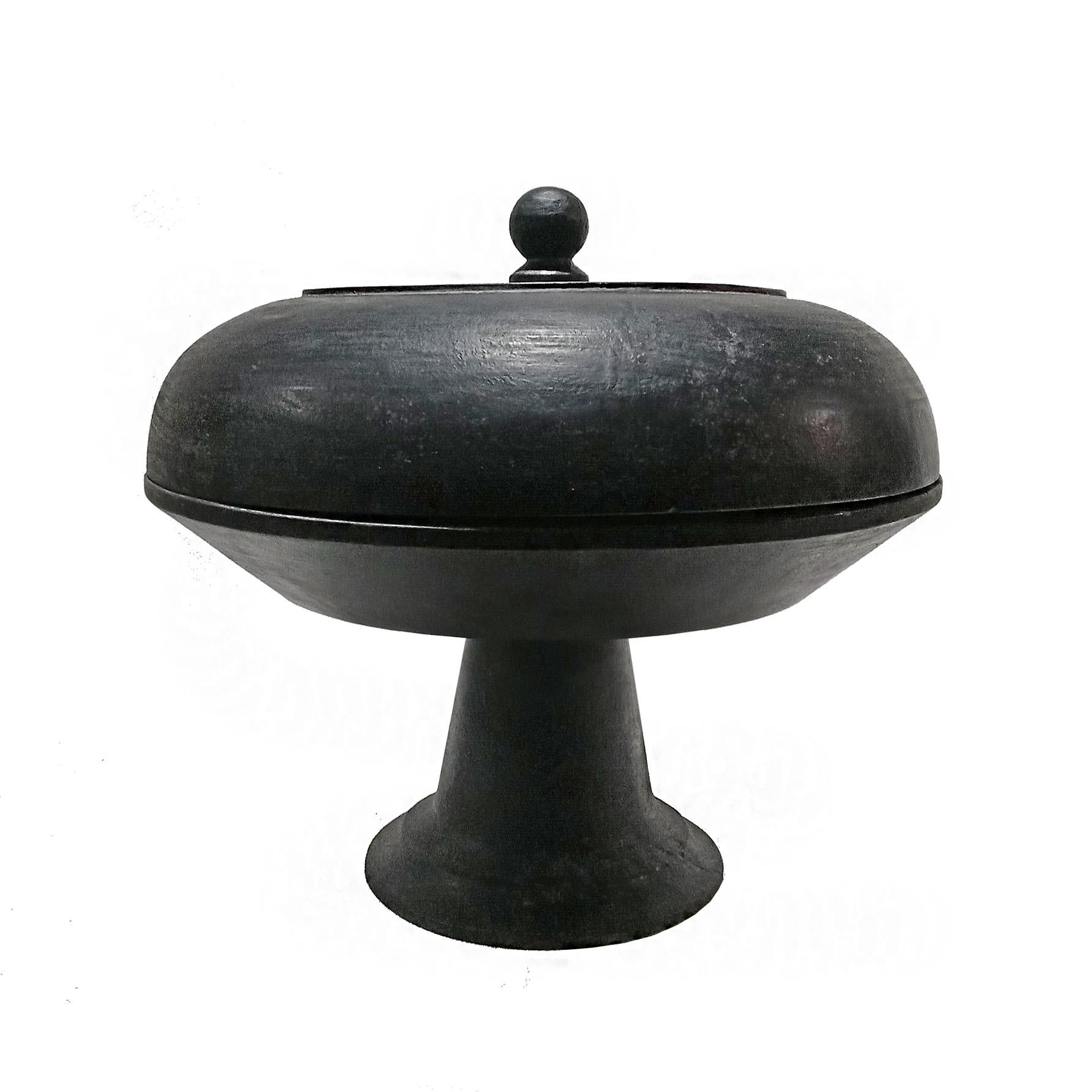 A circular pedestal serving tray with lid from Indonesia, late 20th Century. 

Hand-carved by local artisans out of a single piece of Jackfruit wood and finished in beautiful satin black stain, with a precisely fitting lid and a turned pedestal