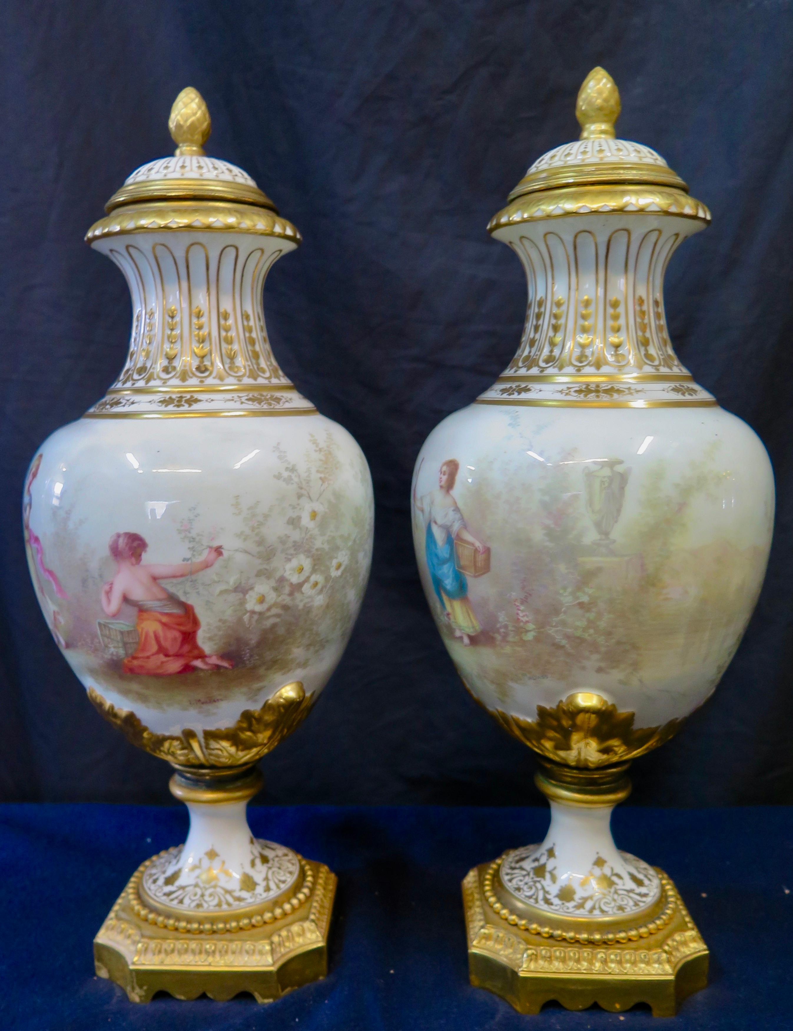 This vintage pair of stunning porcelain covered urns date from the mid 19th century & are attributed to Sevres. Each urn is beautifully decorated with charming colorful hand painted scenes of maidens & baby cherubs within a garden background. These